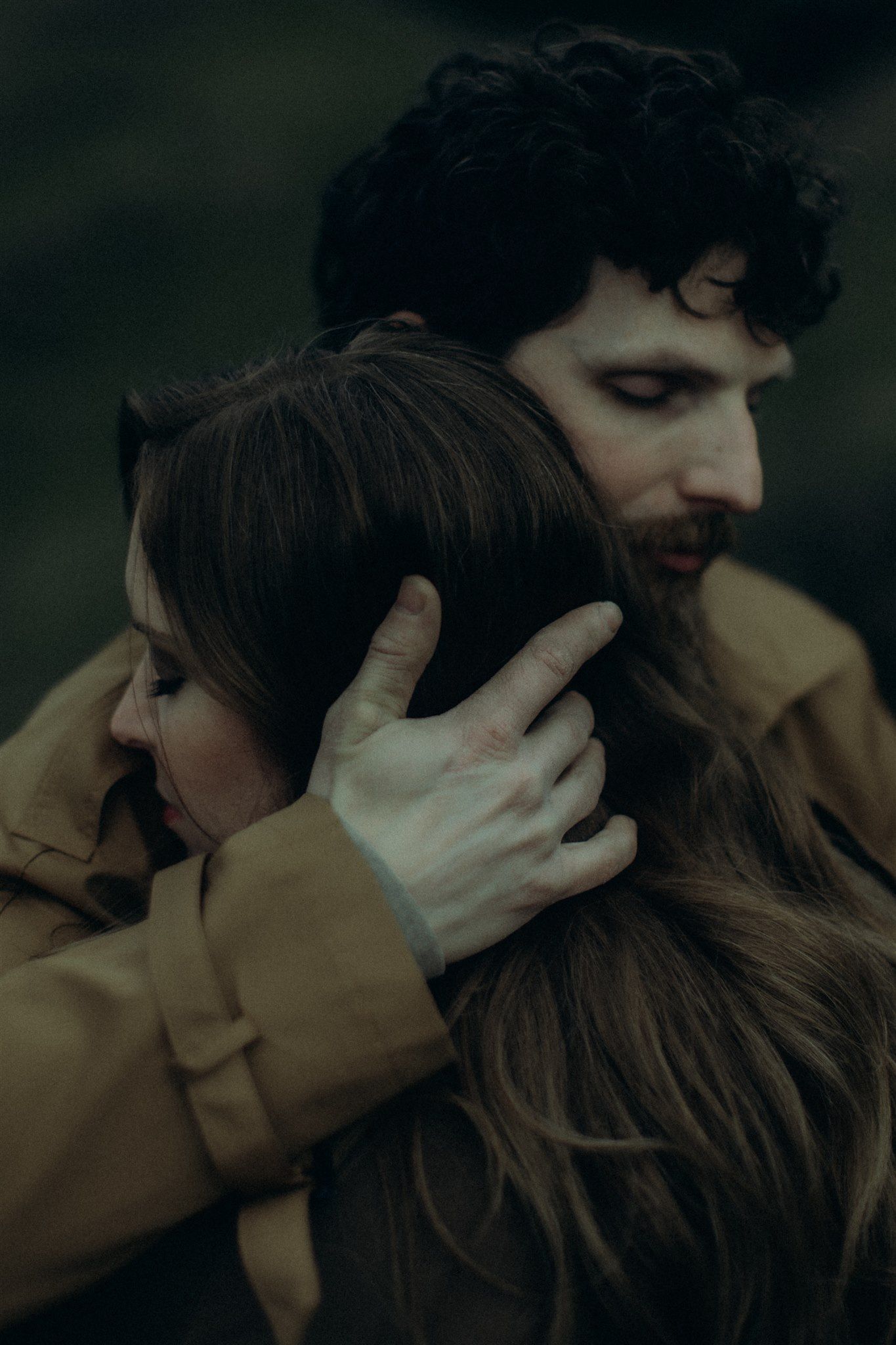 An intimate moment captured in dark, moody lighting against a natural backdrop captured by a destination elopement photographer.