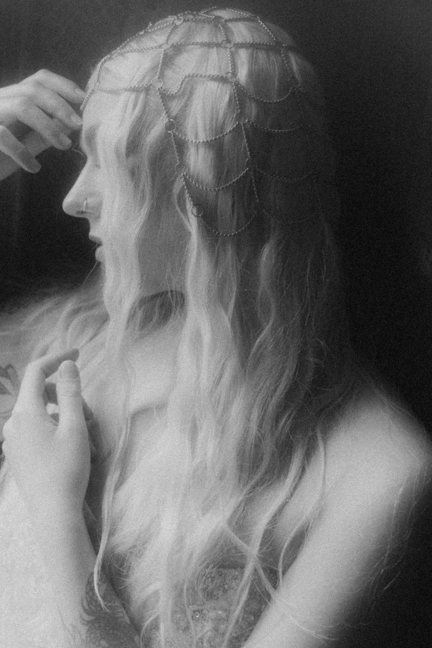 Blurred black and white close-up of flowing white fabric and hair creating an ethereal effect.