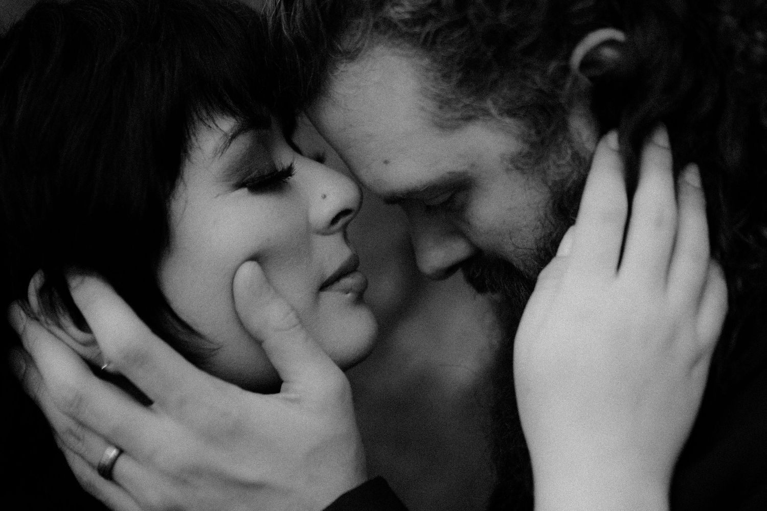 Intimate black and white close-up of a tender romantic moment between two silhouettes.