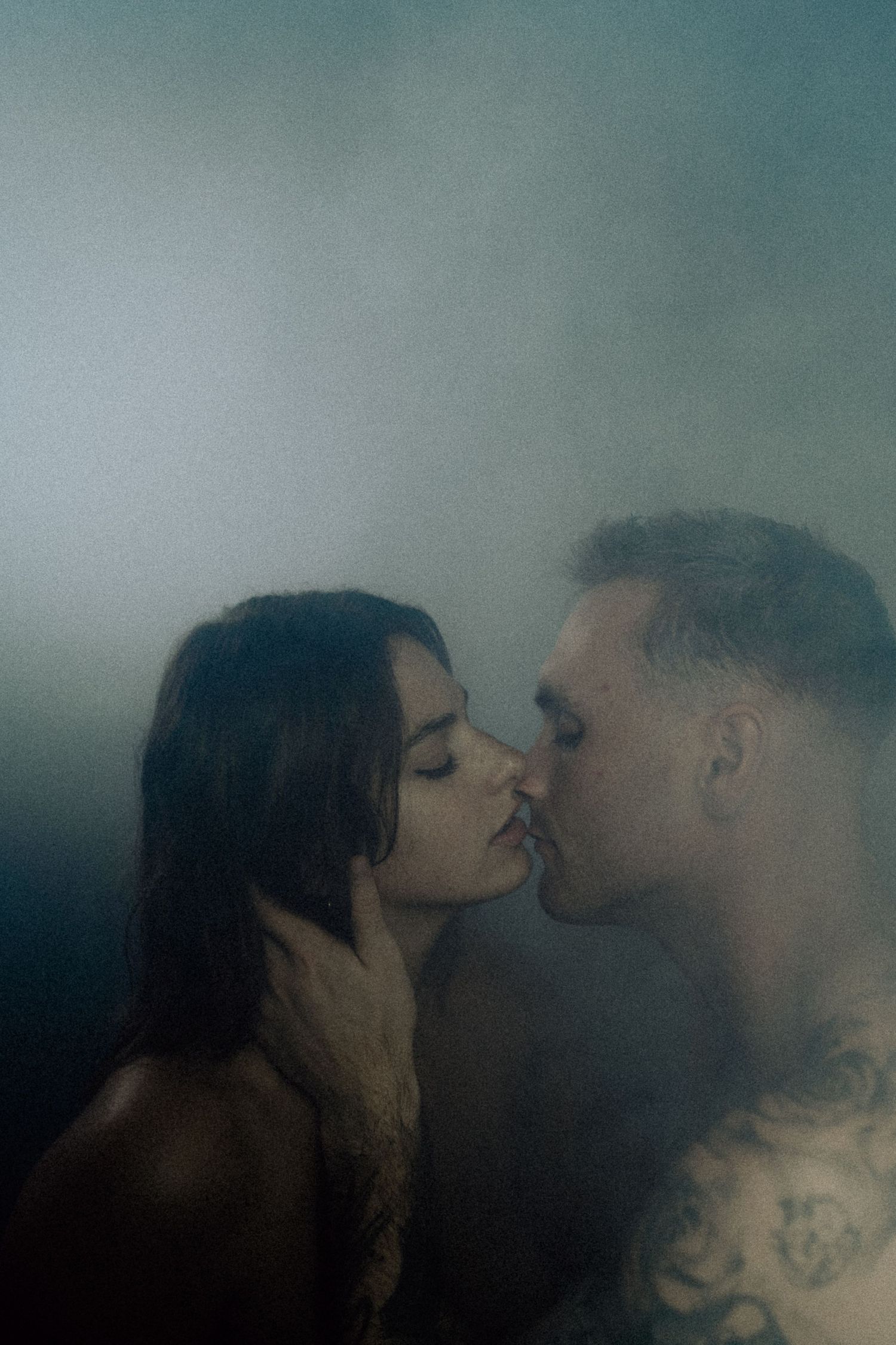 Moody and atmospheric portrait series with blue tones showing intimate moments between a couple.