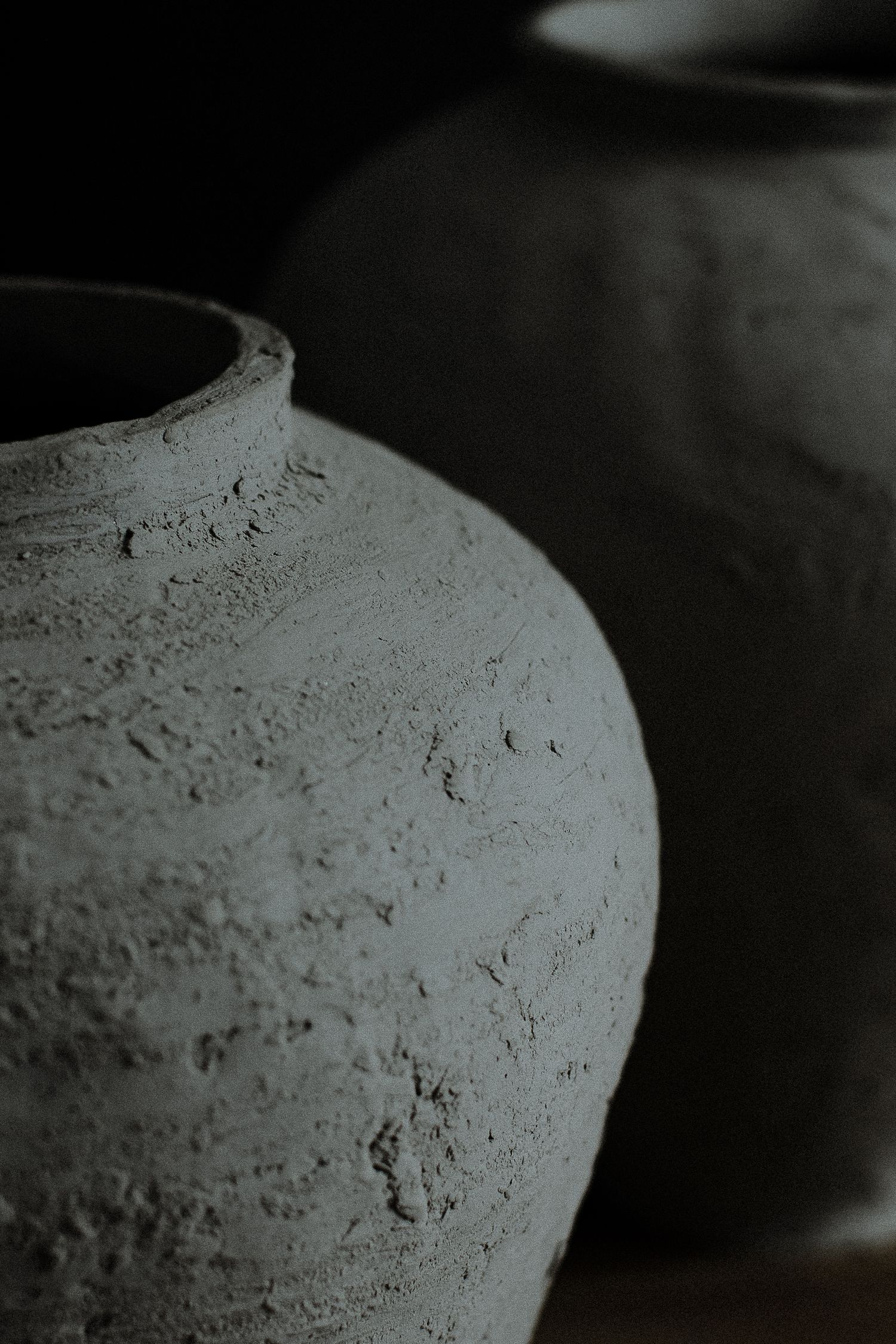 A sequence of five black and white close-up photos showing the textured surface of a clay pot or ceramic vessel.