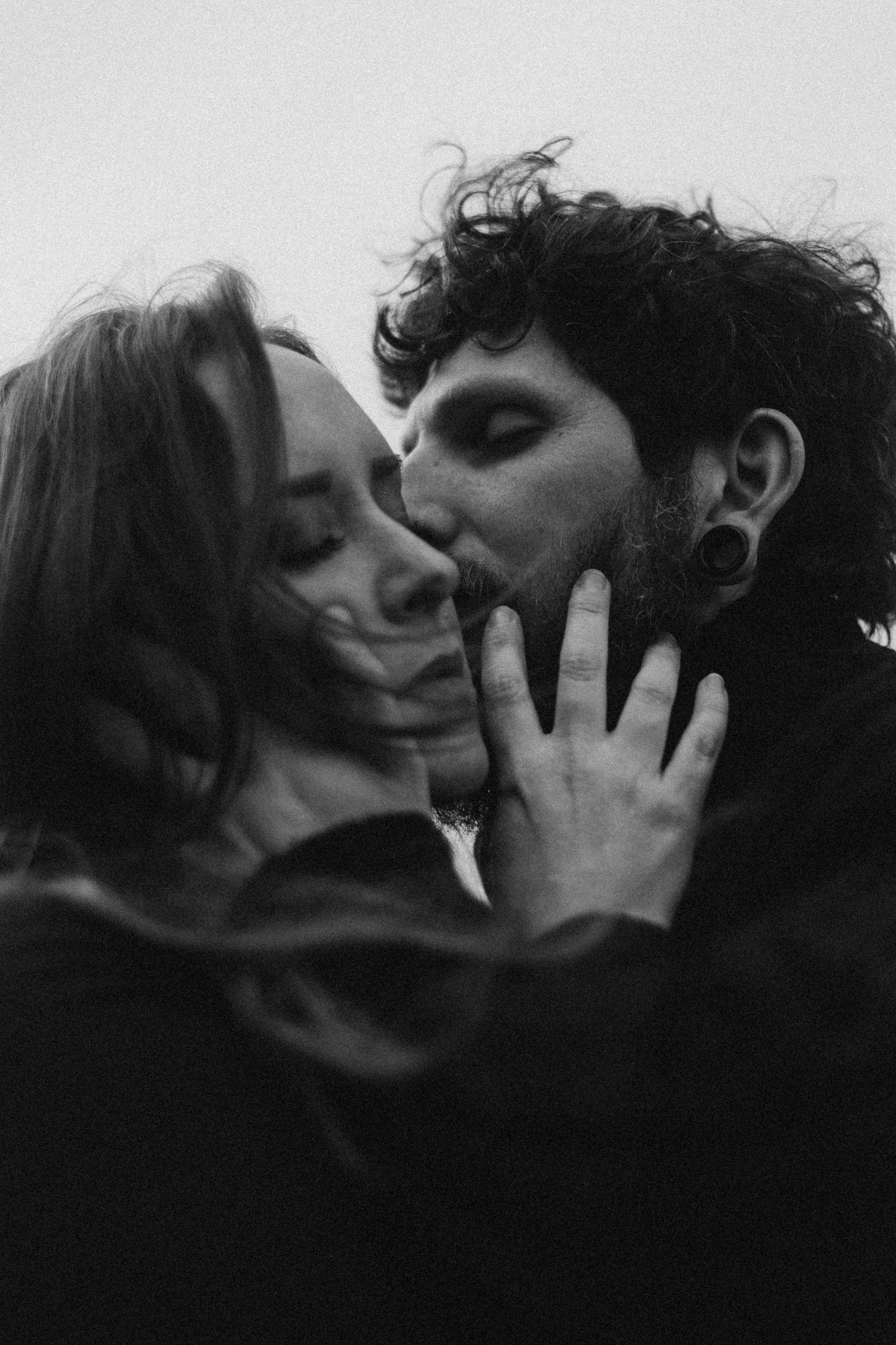 A series of black and white intimate photographs showing tender moments between two people kissing in silhouette.