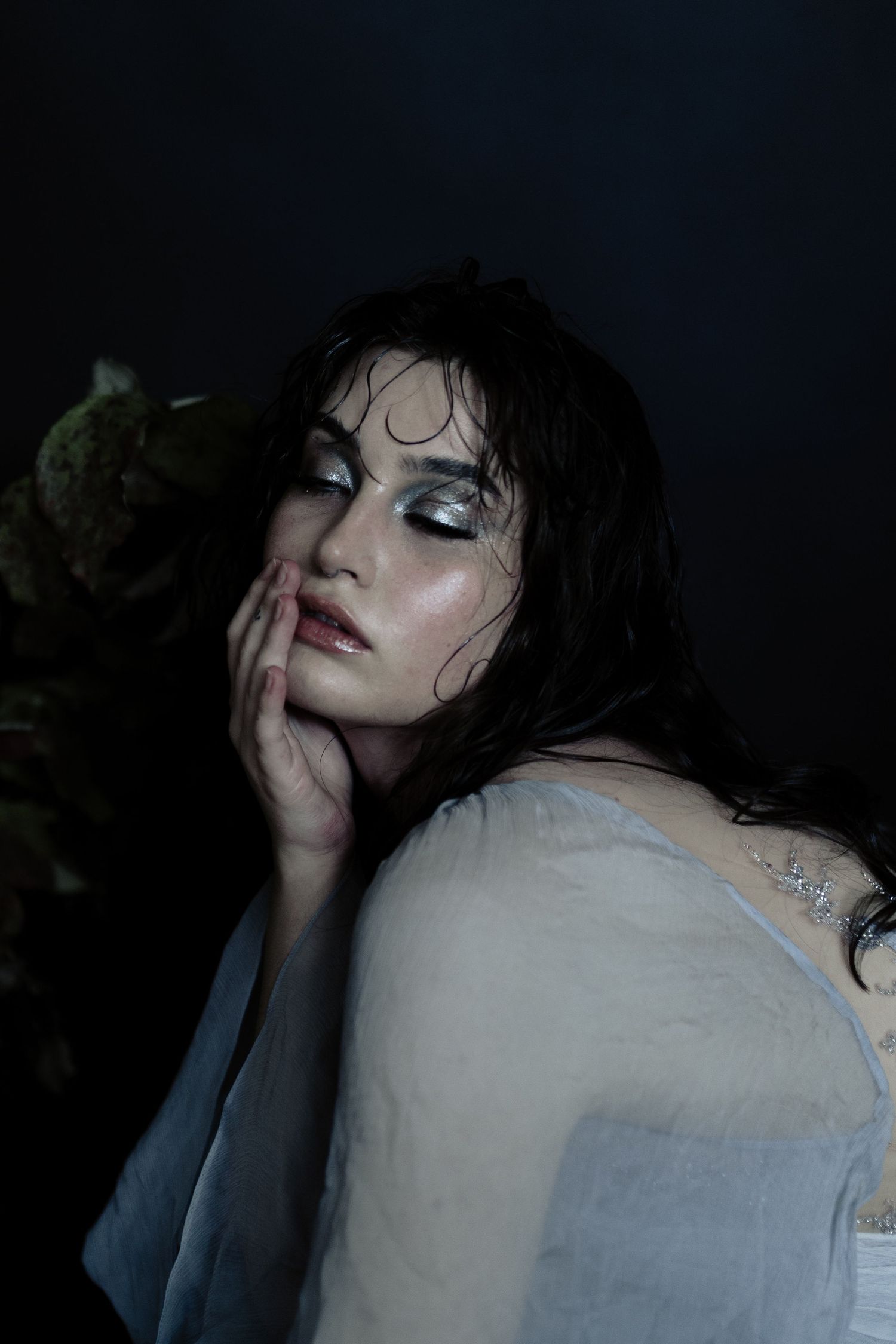 Artistic dark portrait series showing dramatic angles and moody lighting with wet hair and pale skin tones.