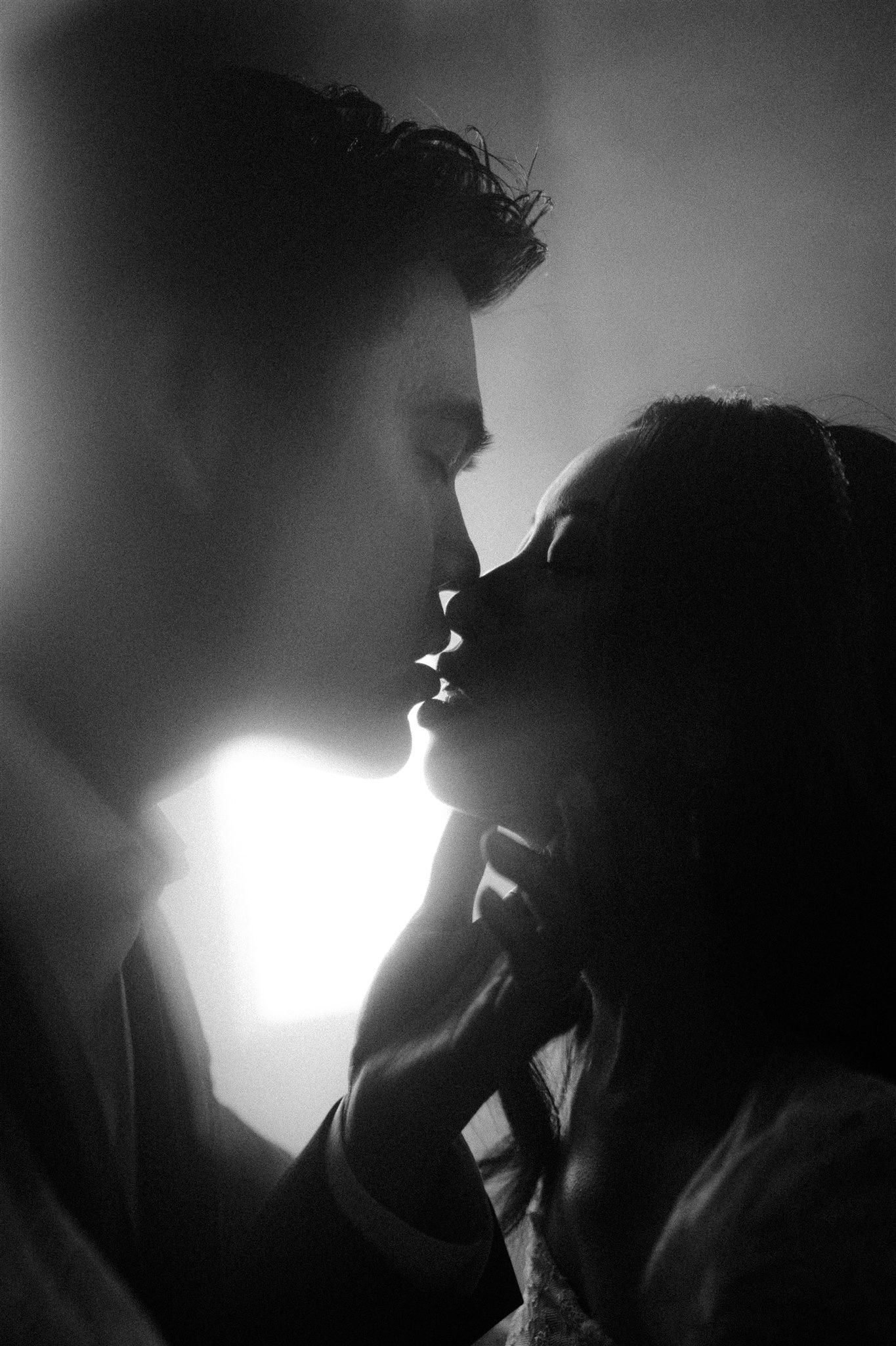 Dramatic black and white silhouettes of a couple in an intimate moment captured by a destination elopement photographer.