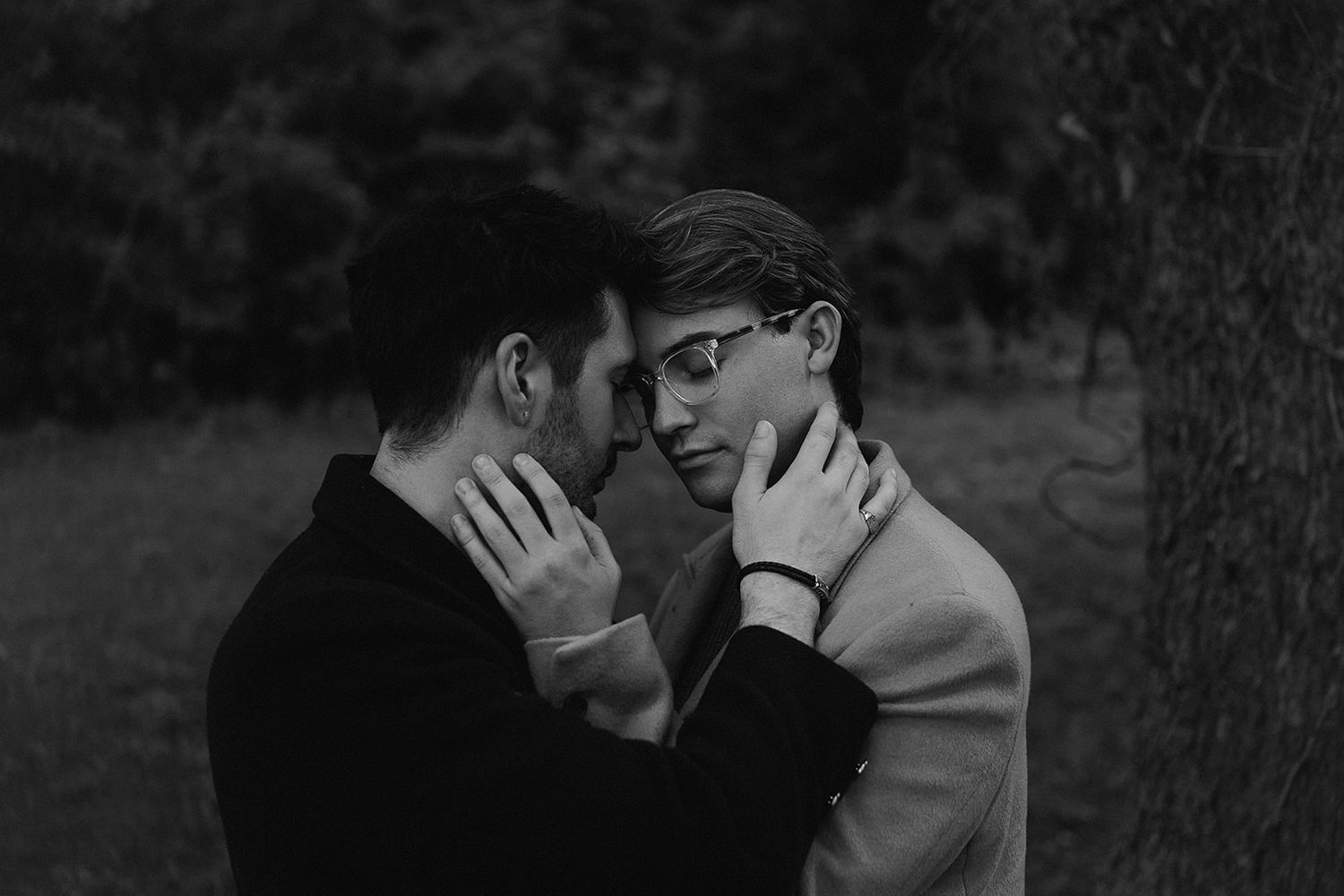 Black and white photograph of people dancing together in an intimate embrace at what appears to be a formal event.