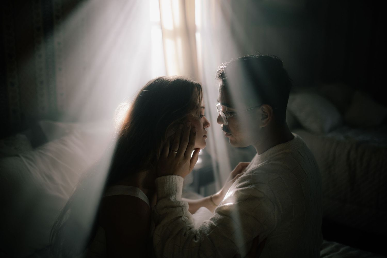 Ethereal backlit scene with soft light streaming between two figures.