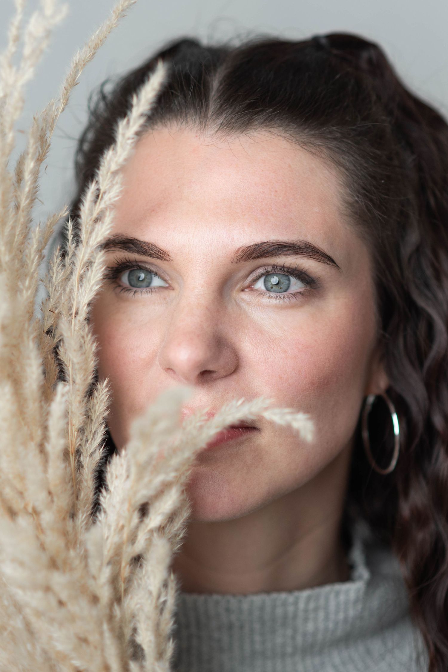 Artistic portrait with dried pampas grass creating a soft, natural frame.