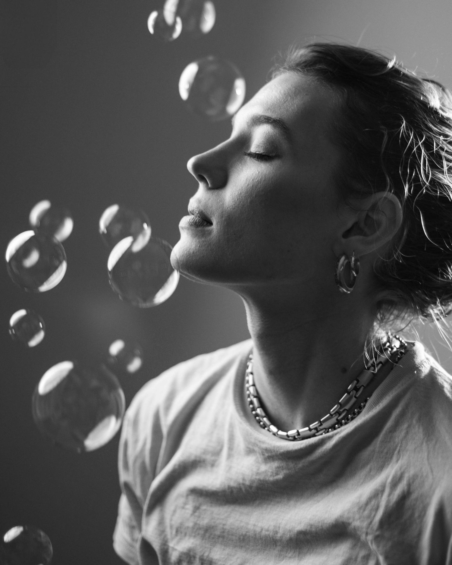 Black and white sequence of soap bubbles floating around in dramatic lighting.