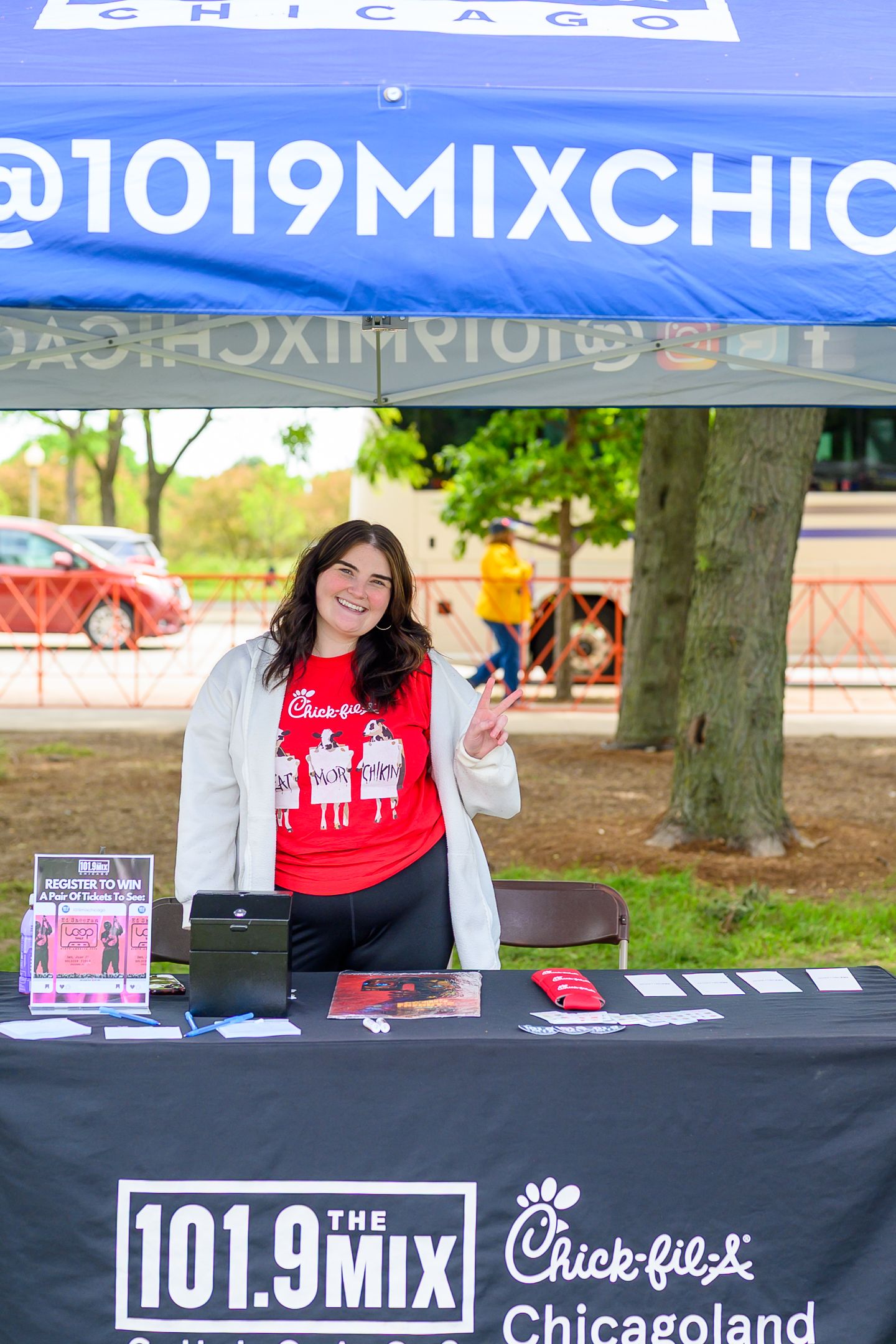 Smiling woman at 101.9 The Mix and Chick-fil-A Chicagoland promotional booth outdoors.
