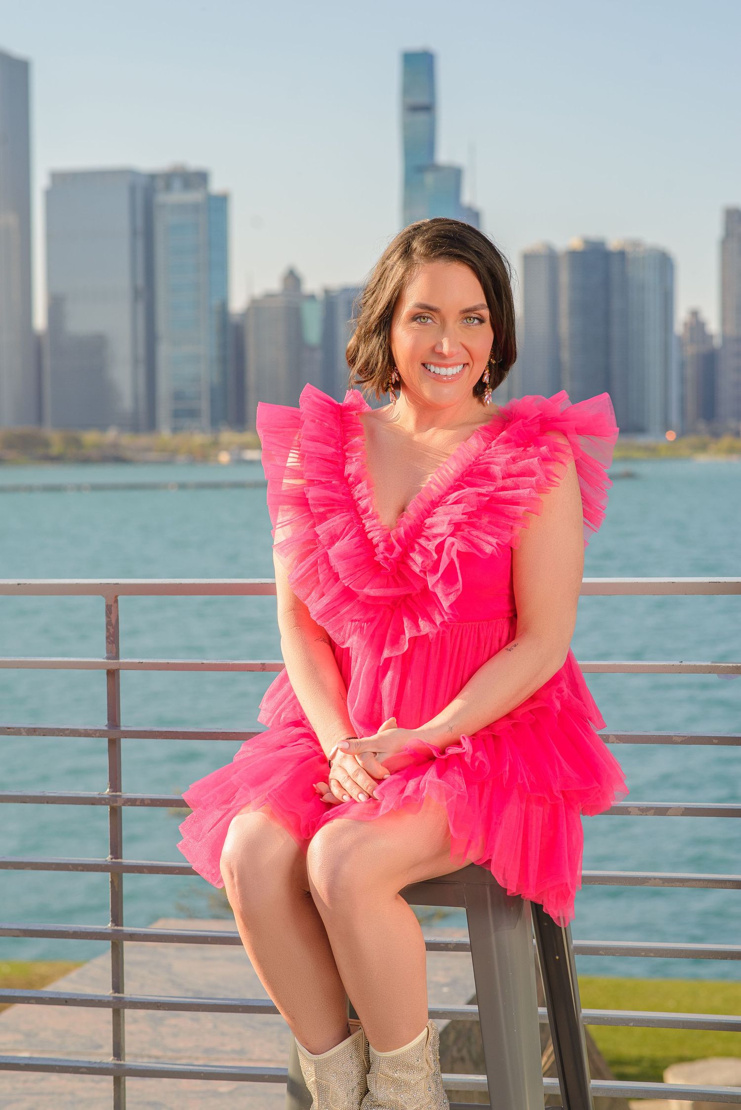 A bright pink tulle dress stands out against the Chicago skyline and Lake Michigan waterfront on a sunny day.