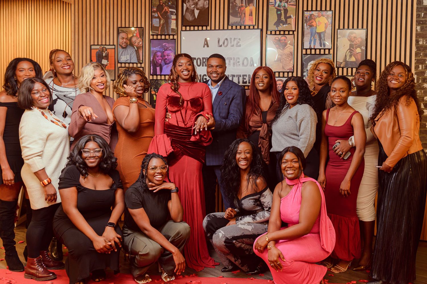 Large group of diverse women posing with a man at an elegant film or book premiere event.
