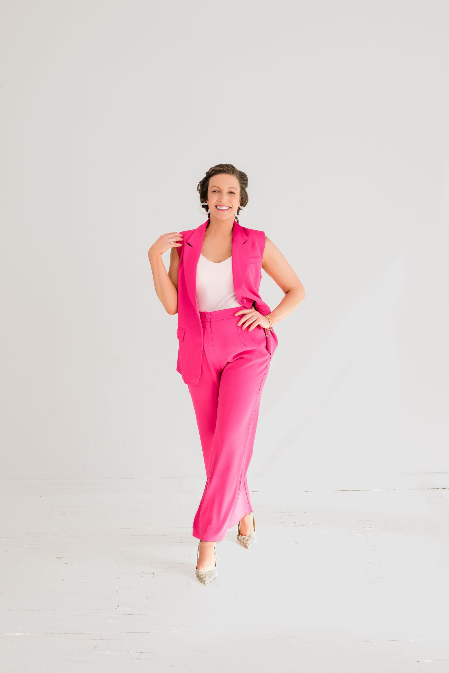 Person in vibrant pink dress strikes dynamic poses against white backdrop in four-image sequence.