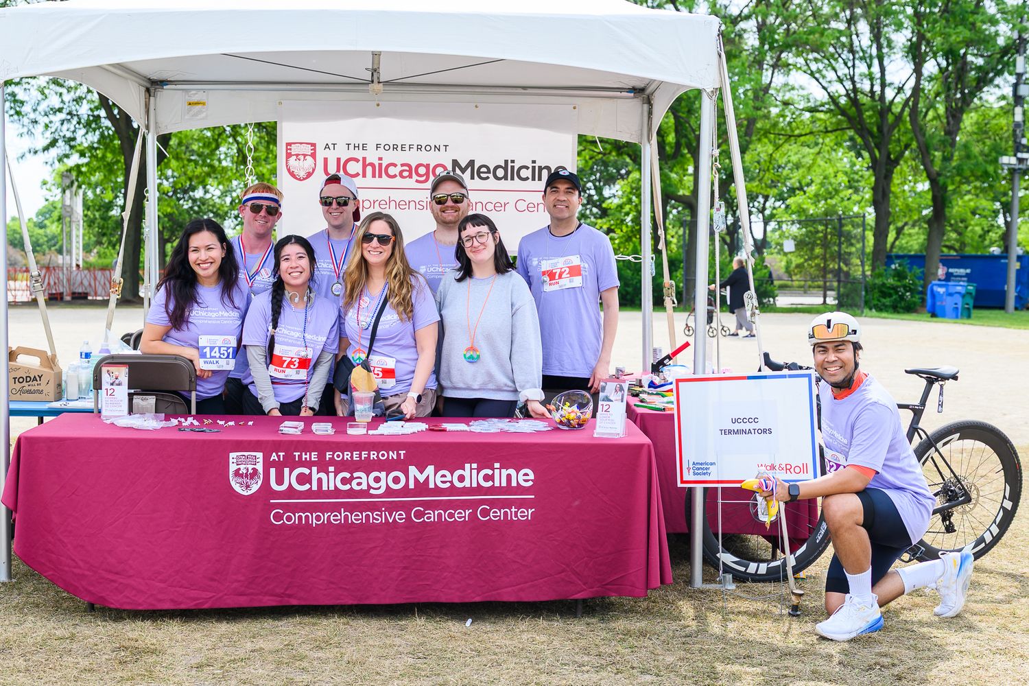 UChicago Medicine Comprehensive Cancer Center team poses at Walk & Roll event booth.