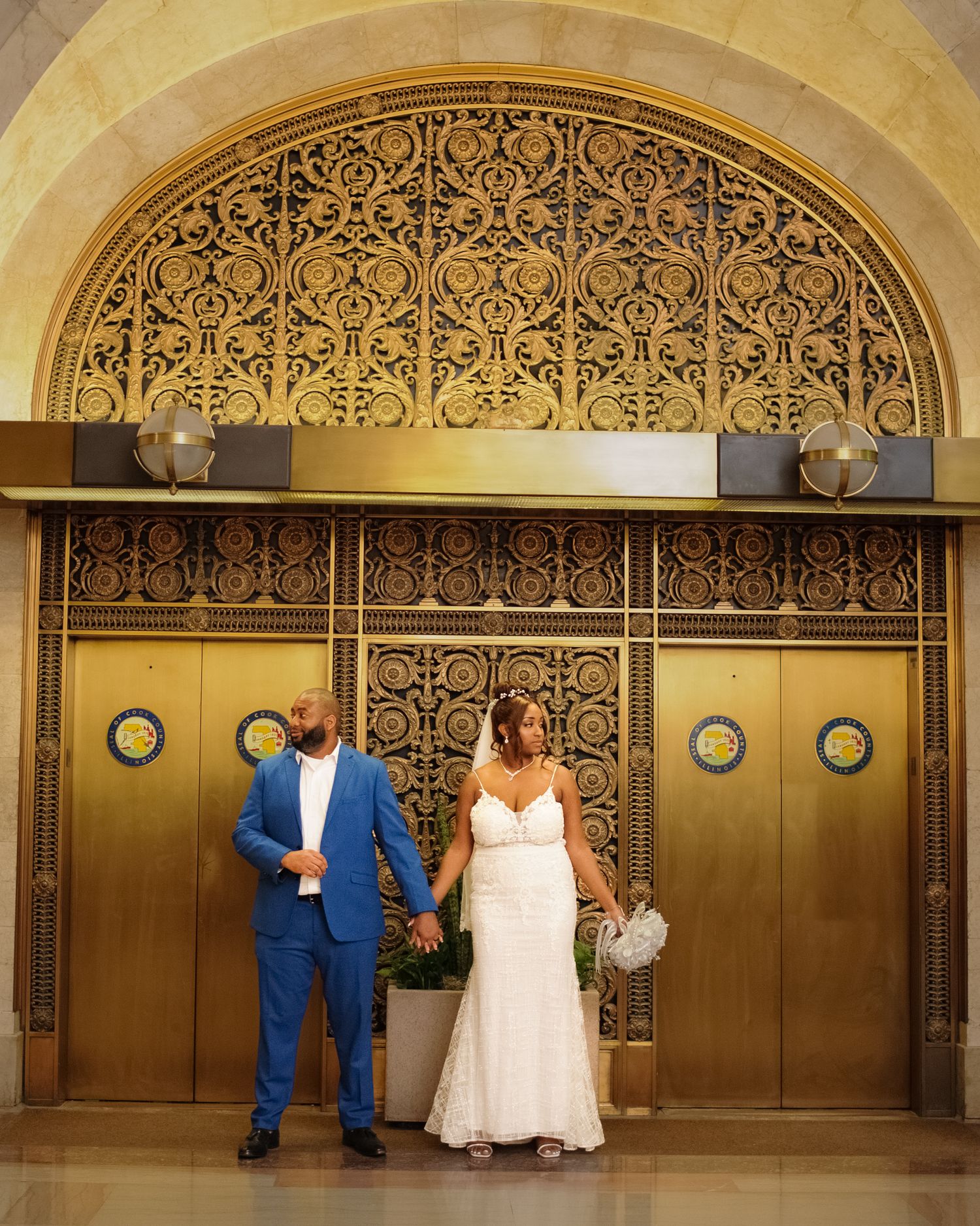 Elegant wedding photo session against ornate metal and wood doors in a historic building.
