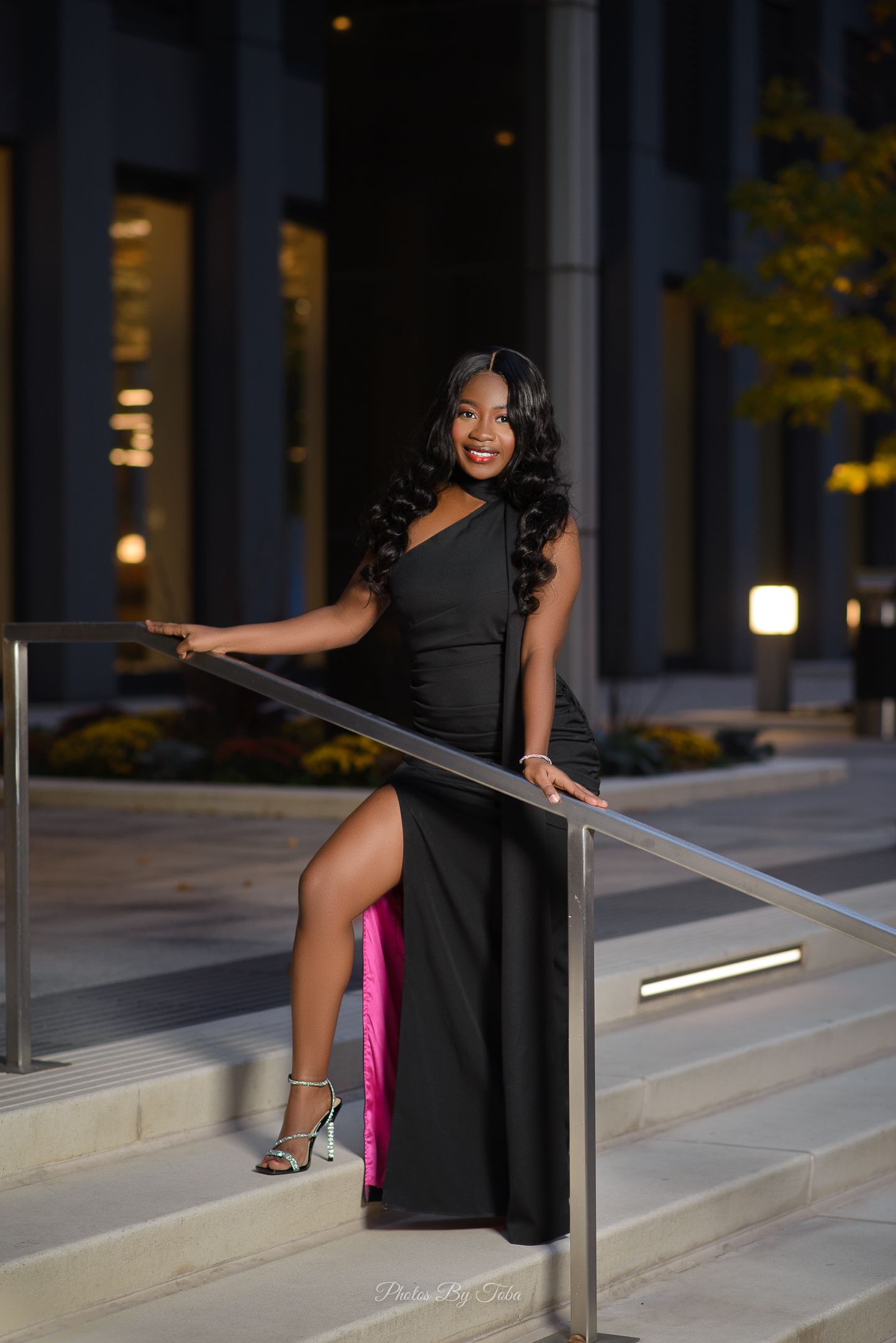 Evening photoshoot on modern building steps with dramatic lighting.