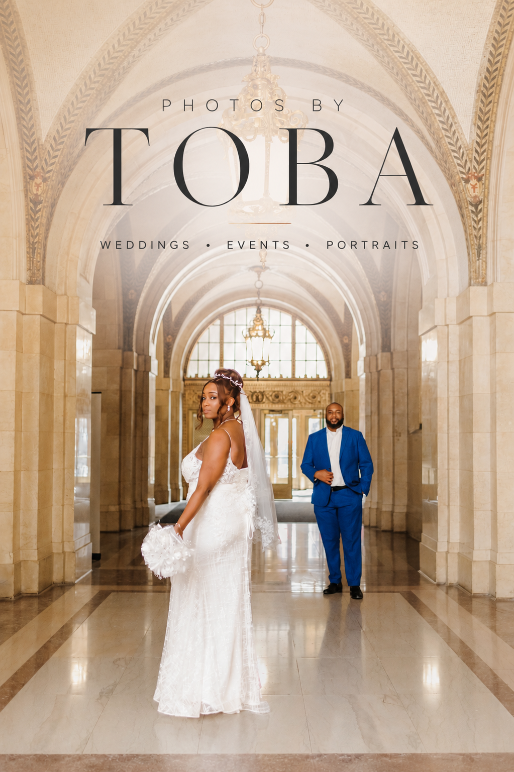 Bride in white gown and groom in blue suit pose in elegant arched hallway for Photos by Toba wedding photography.