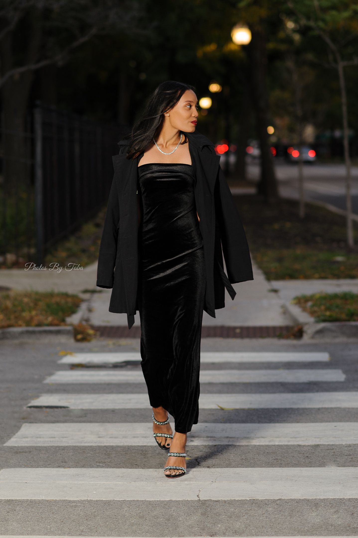 Stylish nighttime portrait session showing black velvet dress and heels on concrete steps.