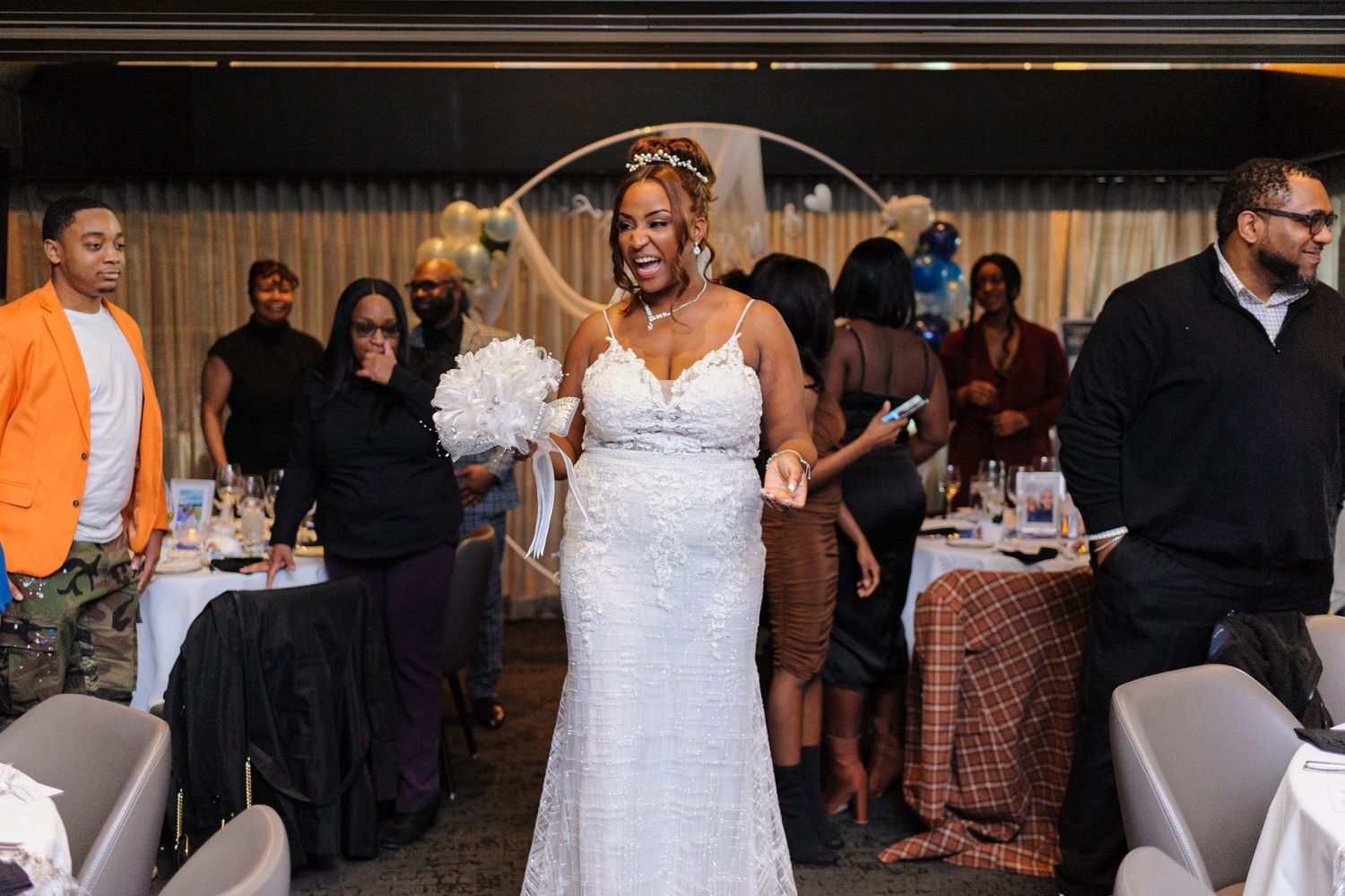 Reception celebration at an elegant venue with white tablecloths and formal decor.