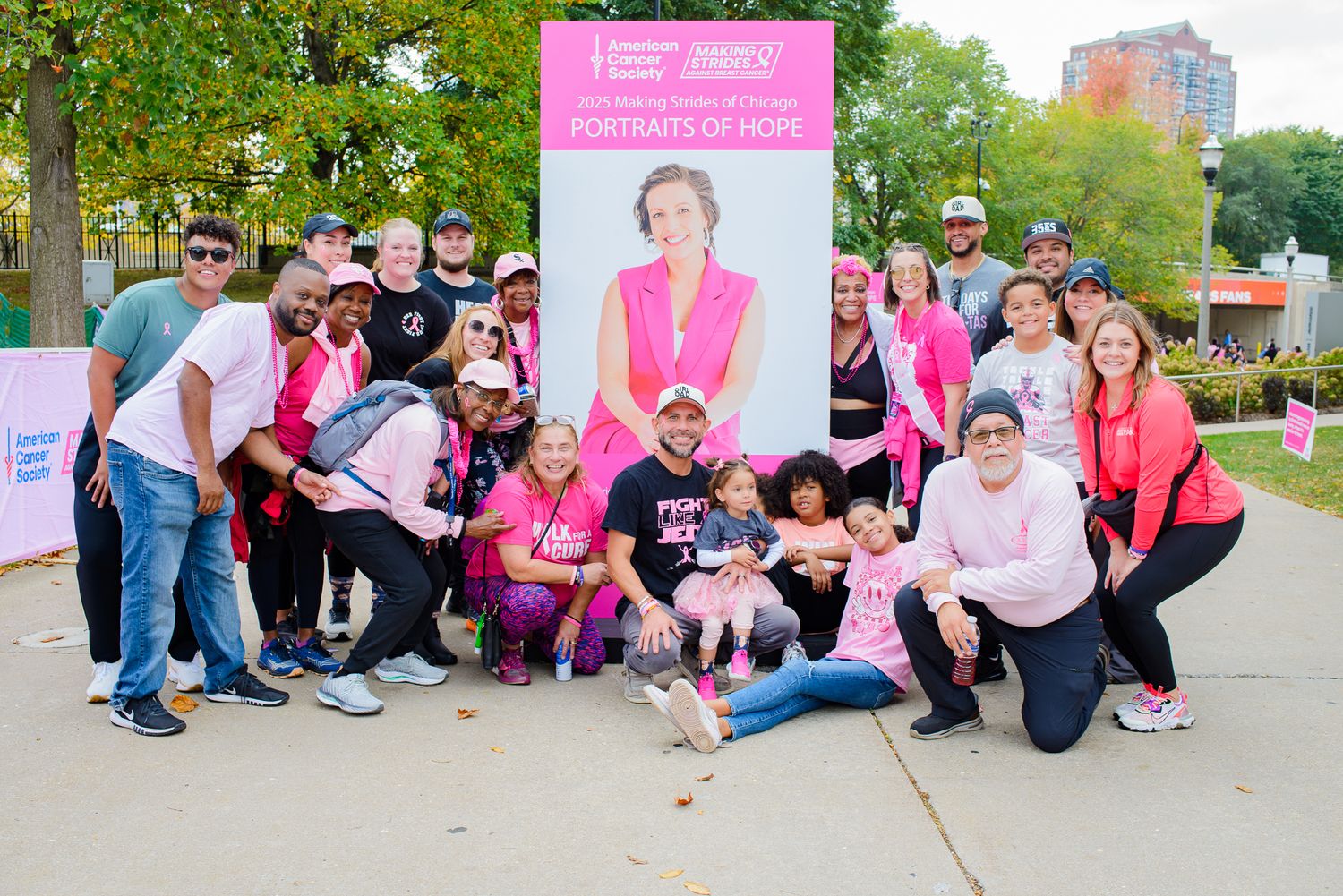 Outdoor group photos of charity event participants gathered on sidewalk with pink banners.