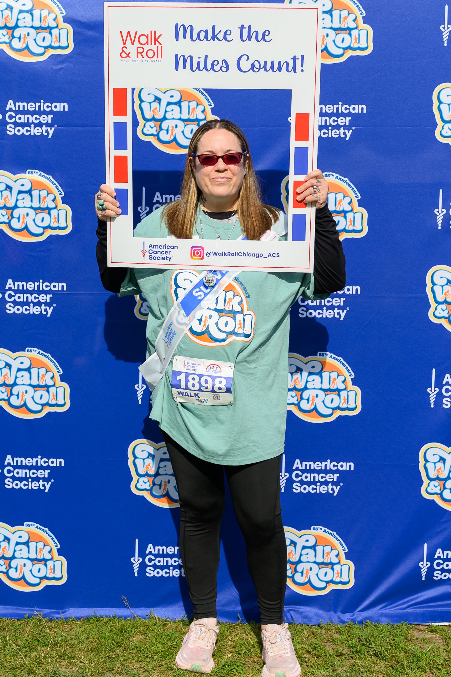 Woman holds Walk & Roll Make the Miles Count frame at American Cancer Society event.