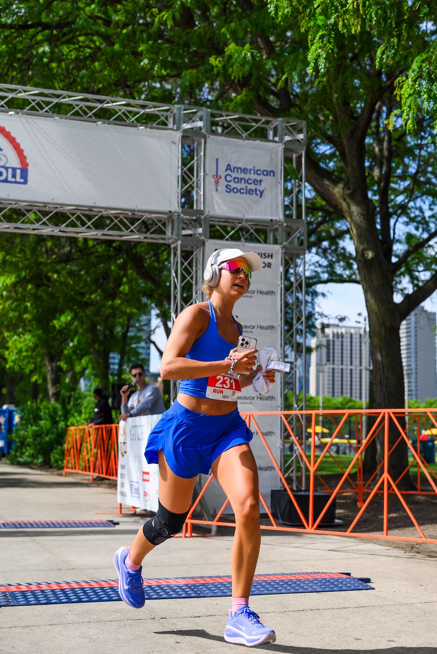 Female runner in blue outfit crosses finish line at American Cancer Society Walk & Roll Chicago race.