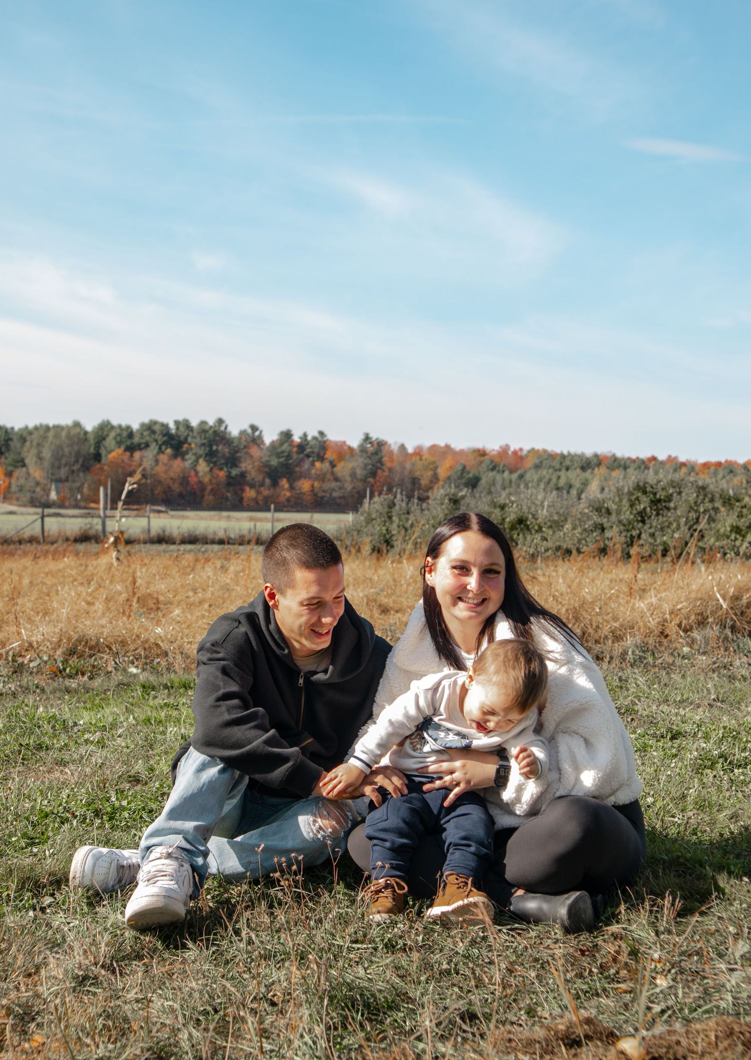 Photographie de famille authentique capturant un moment de complicité entre parents et enfant en Montérégie.