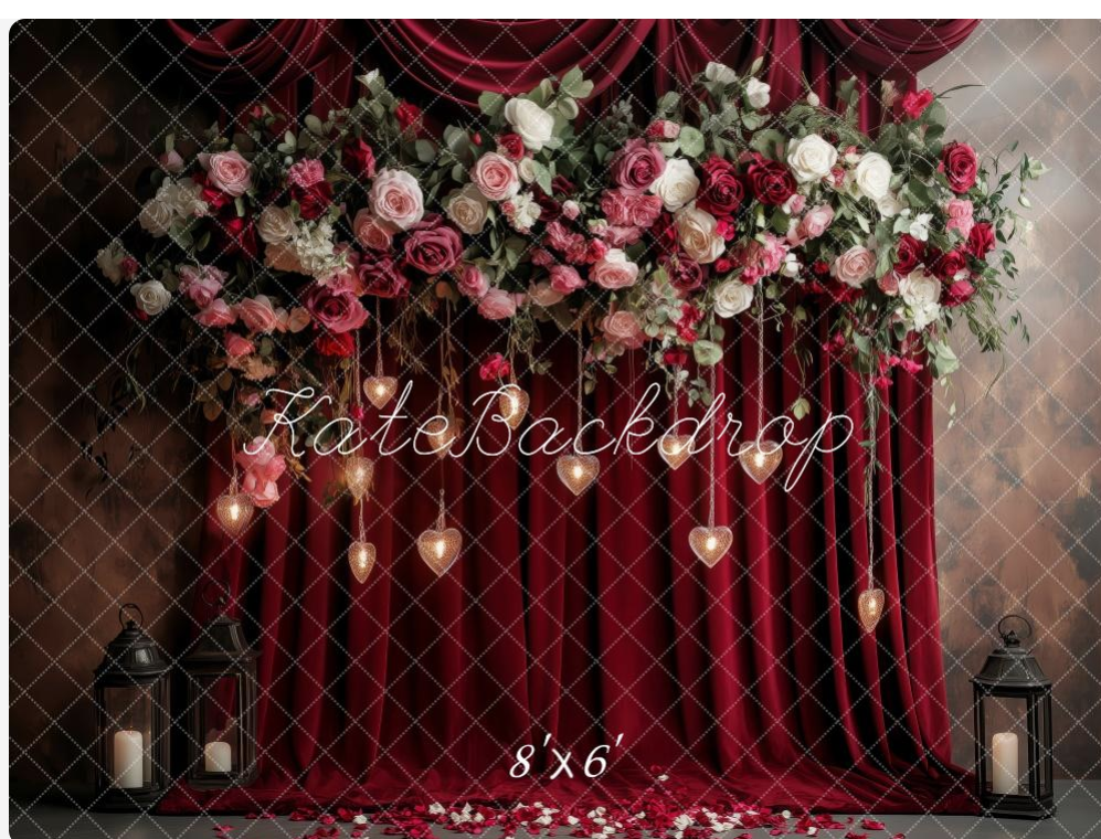 Elegant floral arch with pink and white roses against burgundy velvet drapes, adorned with hanging crystal hearts and lanterns.