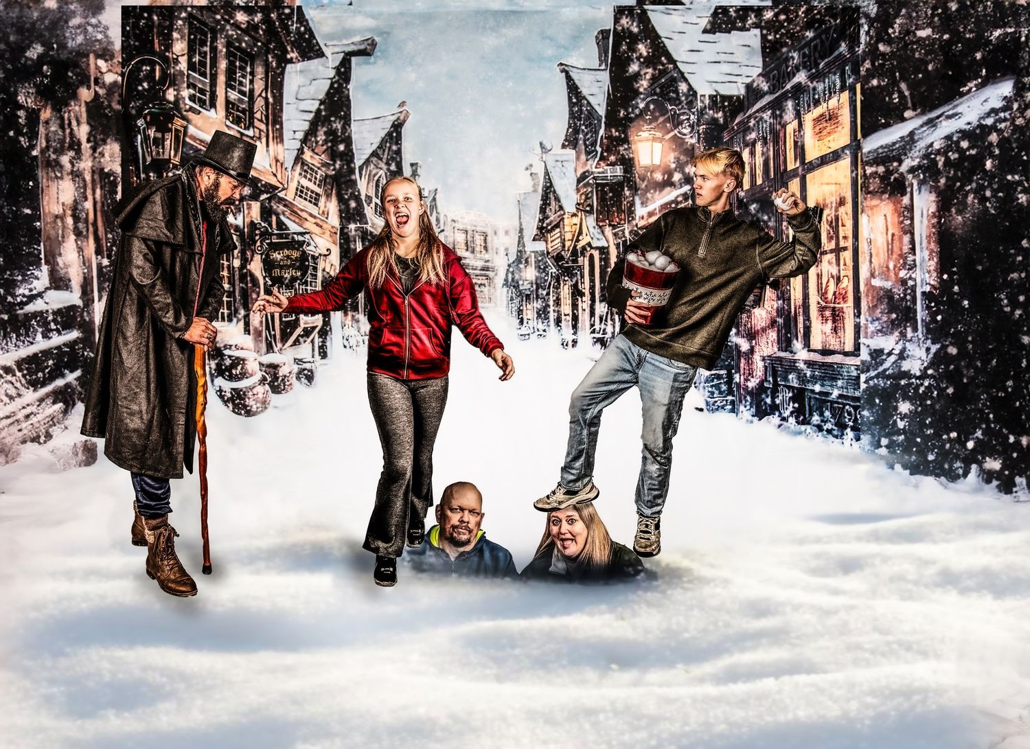 A group enjoying winter fun while sledding and walking down a snowy small town main street with American flags displayed.