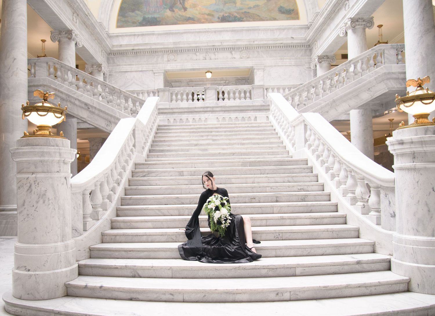 An ornate white marble staircase with grand architecture and balustrades in a luxury building interior.