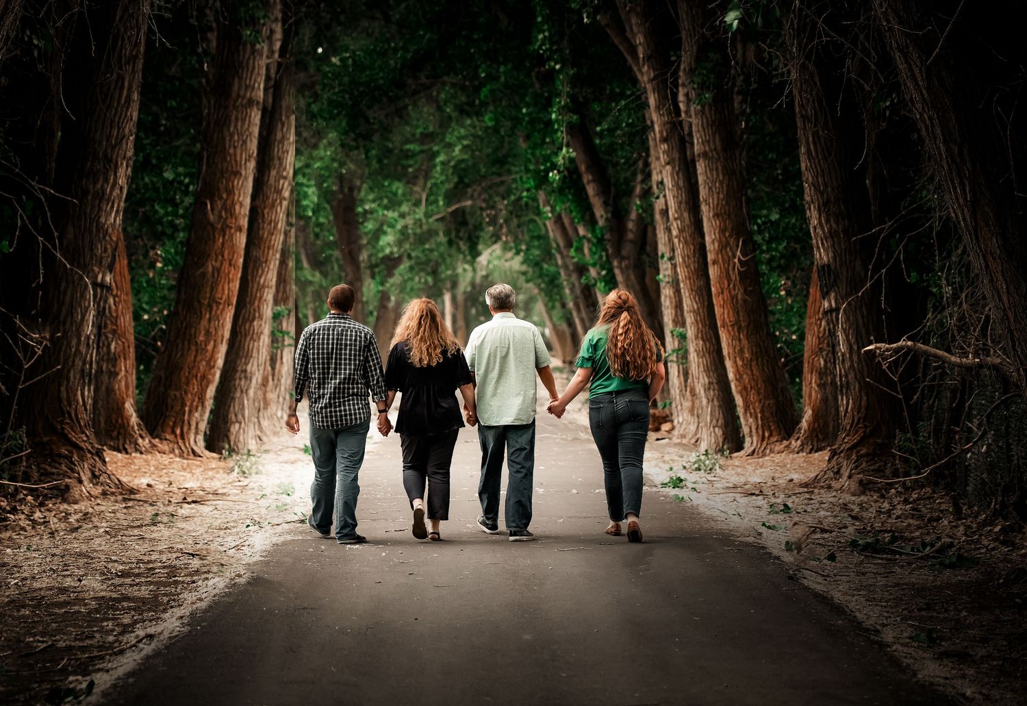 Group walking together on a tree-lined path in a serene forest setting.