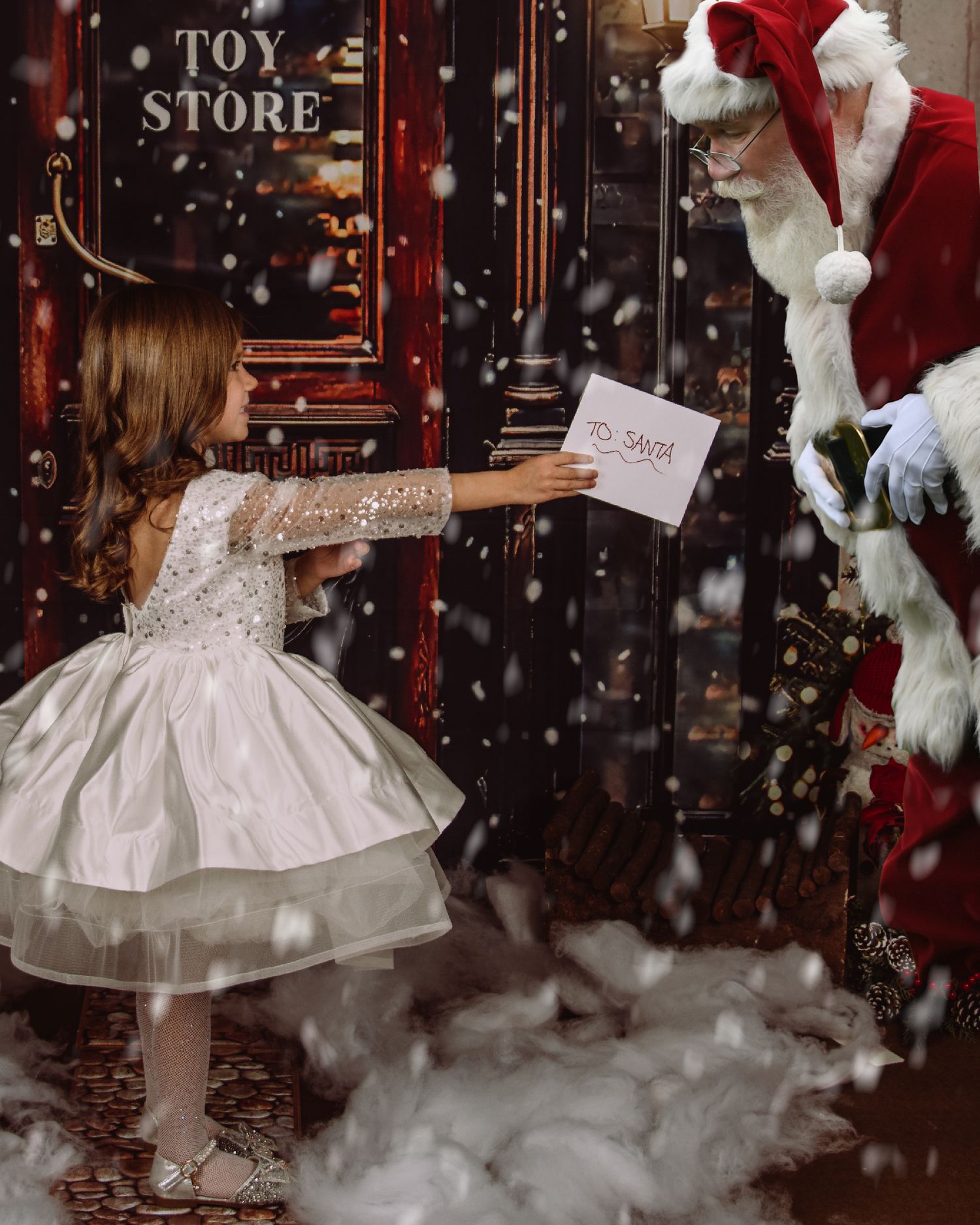 A magical Christmas scene with falling snow and a white dress in front of a vintage toy store window display.