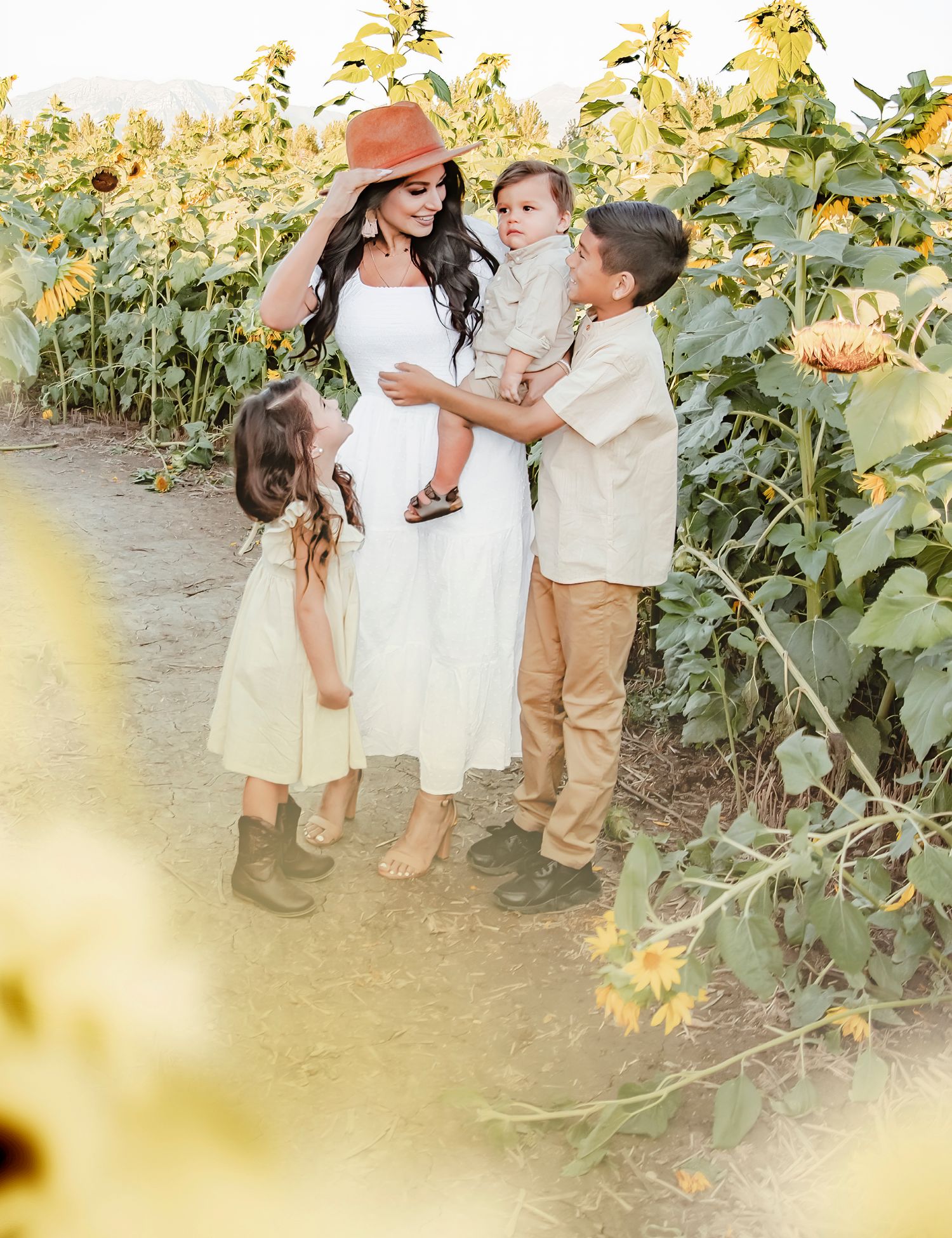 A family sharing joyful moments together in a blooming sunflower field.