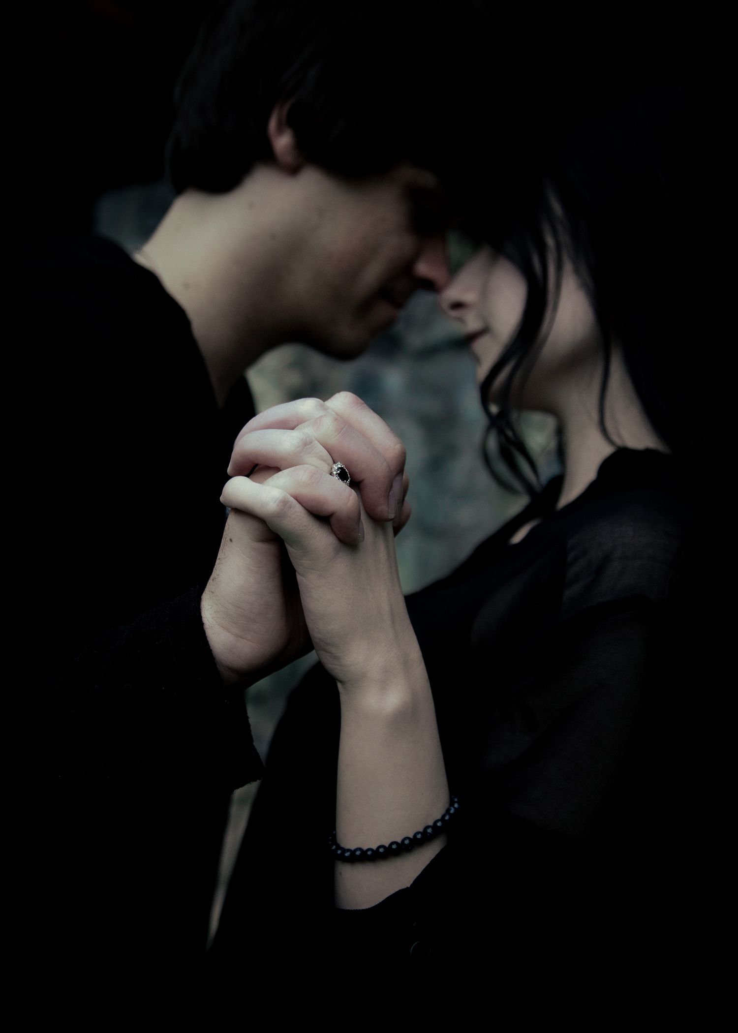Close-up moody scene of two people in intimate embraces with dark shadows creating a cinematic effect.