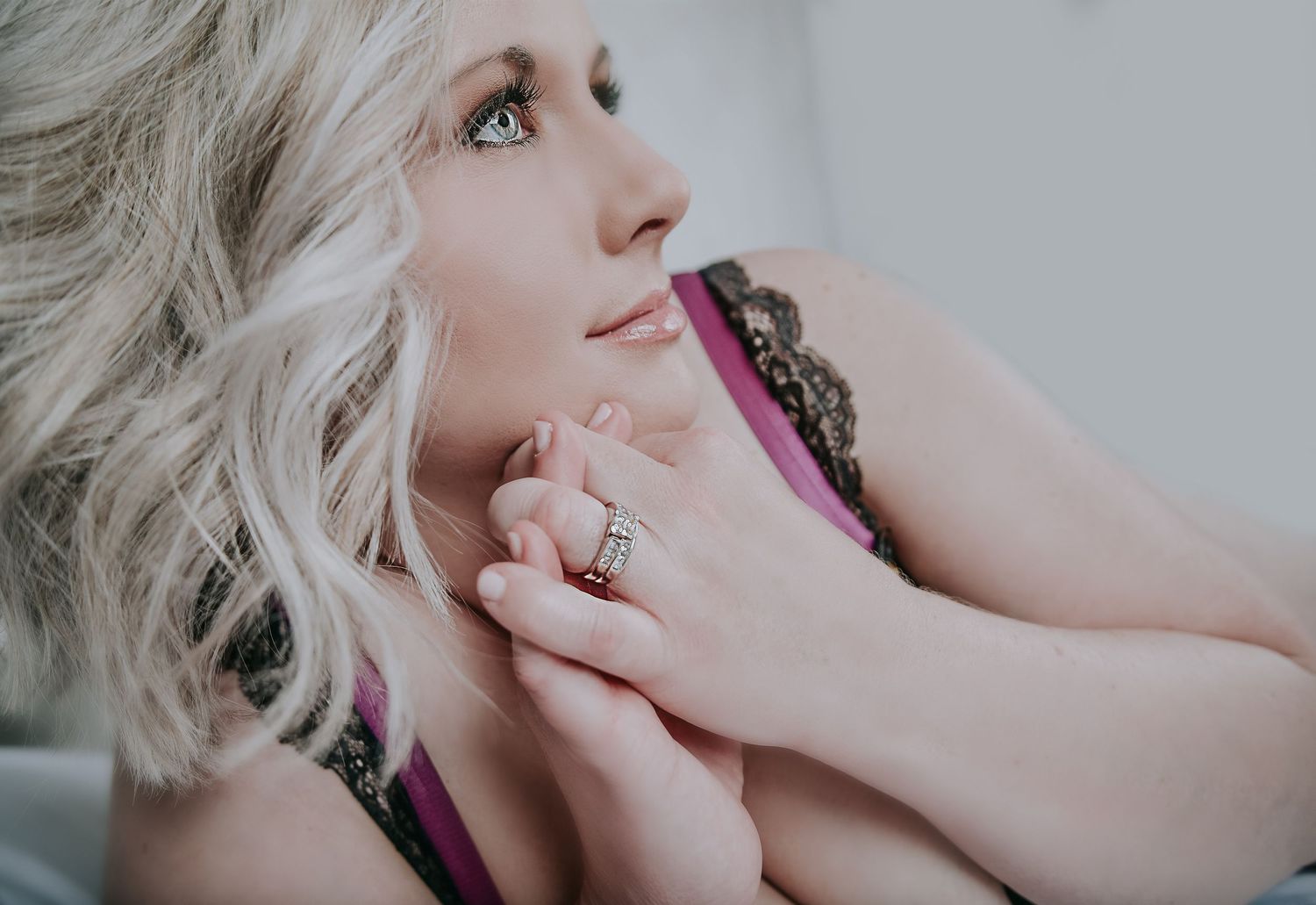 Soft boudoir portrait of a woman with platinum hair in delicate lace.