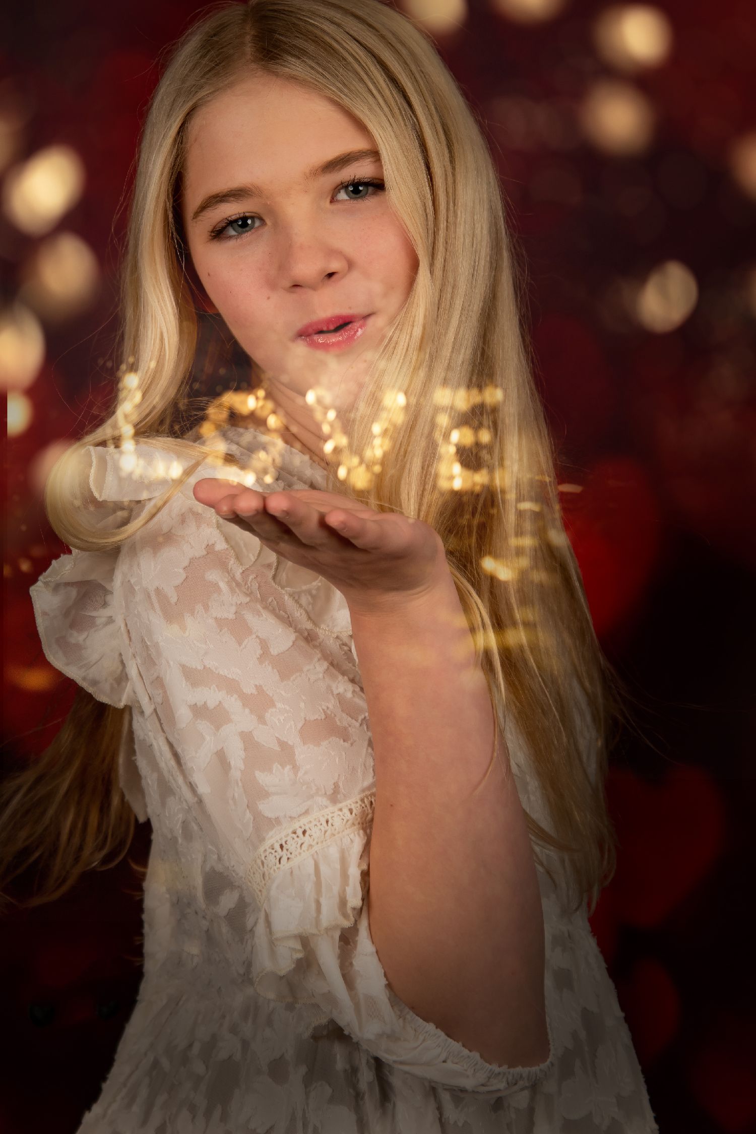 Magical portrait with golden fairy lights against burgundy backdrop.