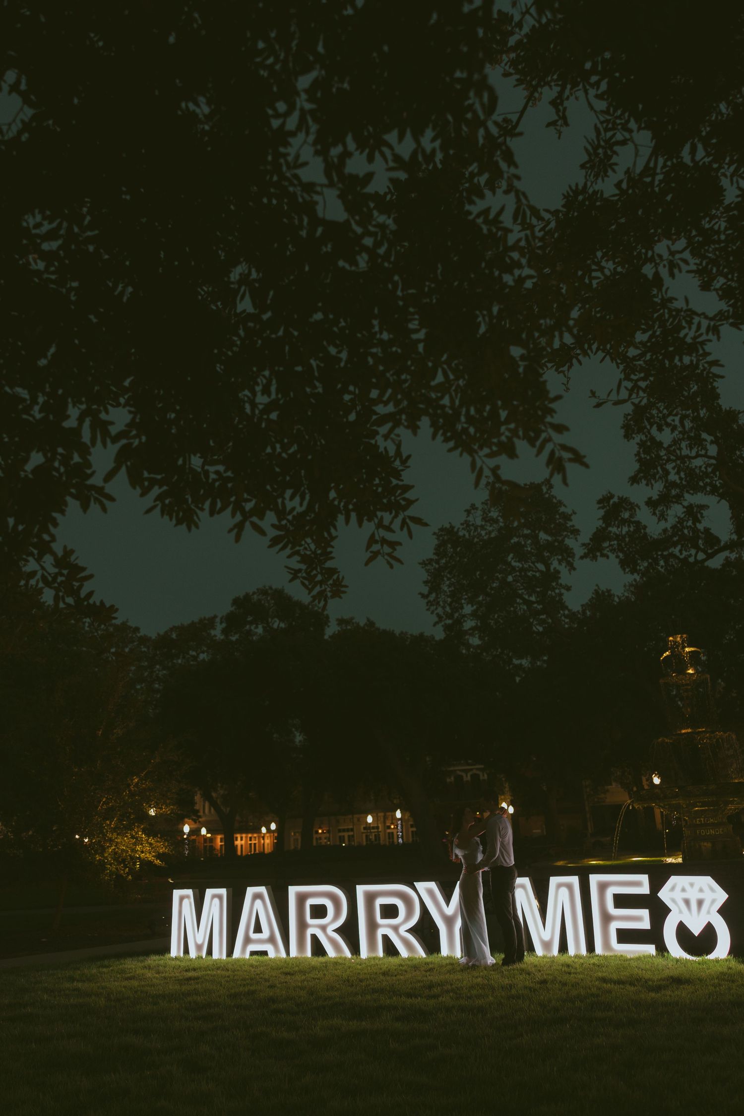 Couple celebrating a surprise proposal in Downtown Mobile, Alabama