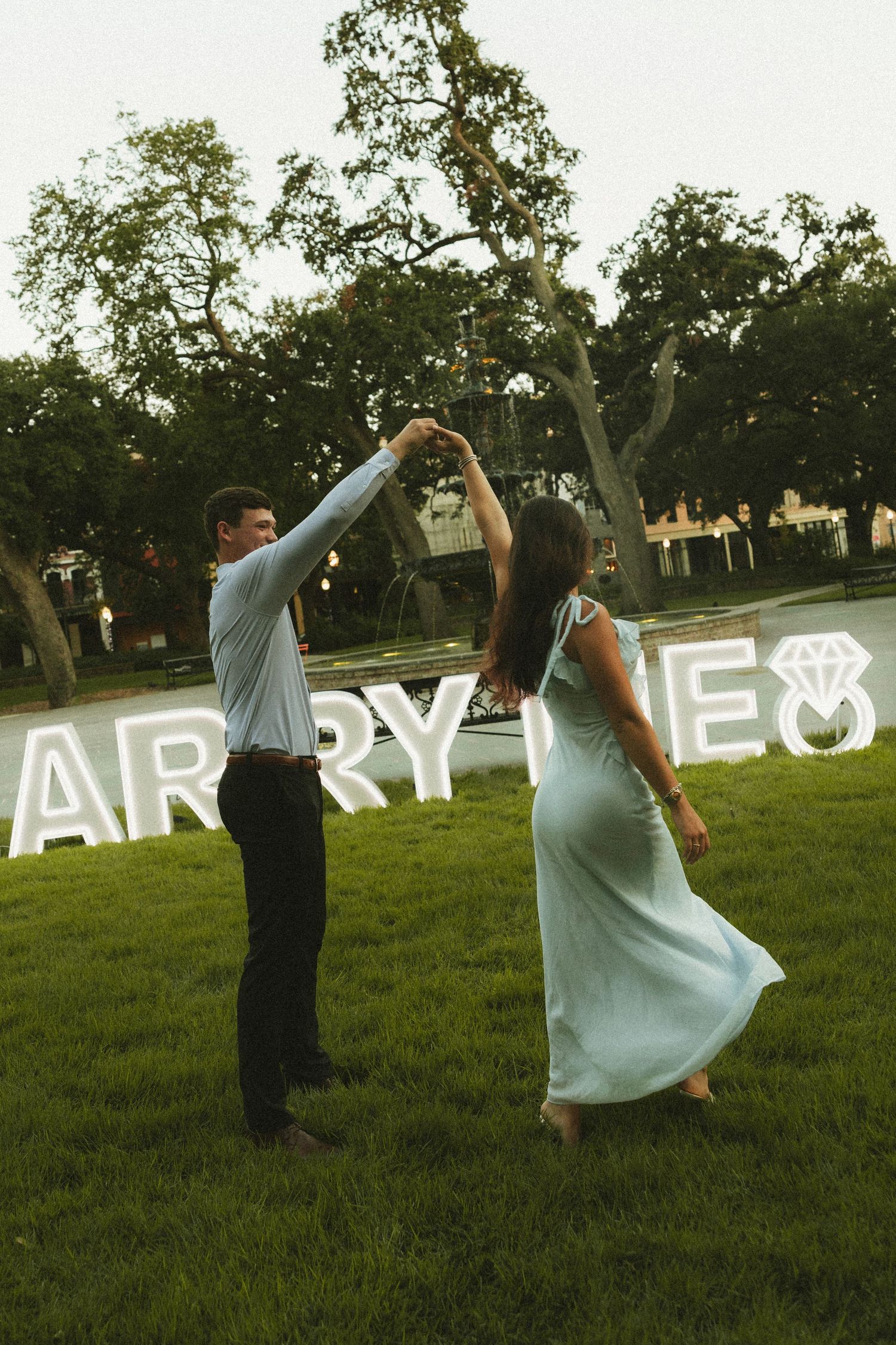 Couple celebrating a surprise proposal in Downtown Mobile, Alabama