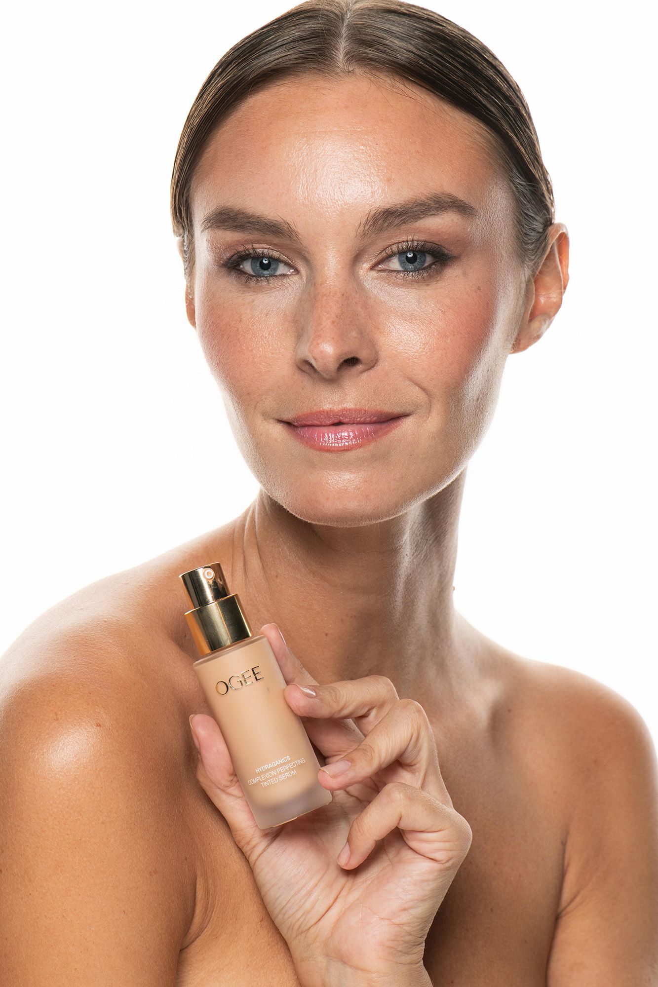 Woman holding a DOPE liquid foundation bottle, showcasing natural glowing skin and subtle makeup on white background.