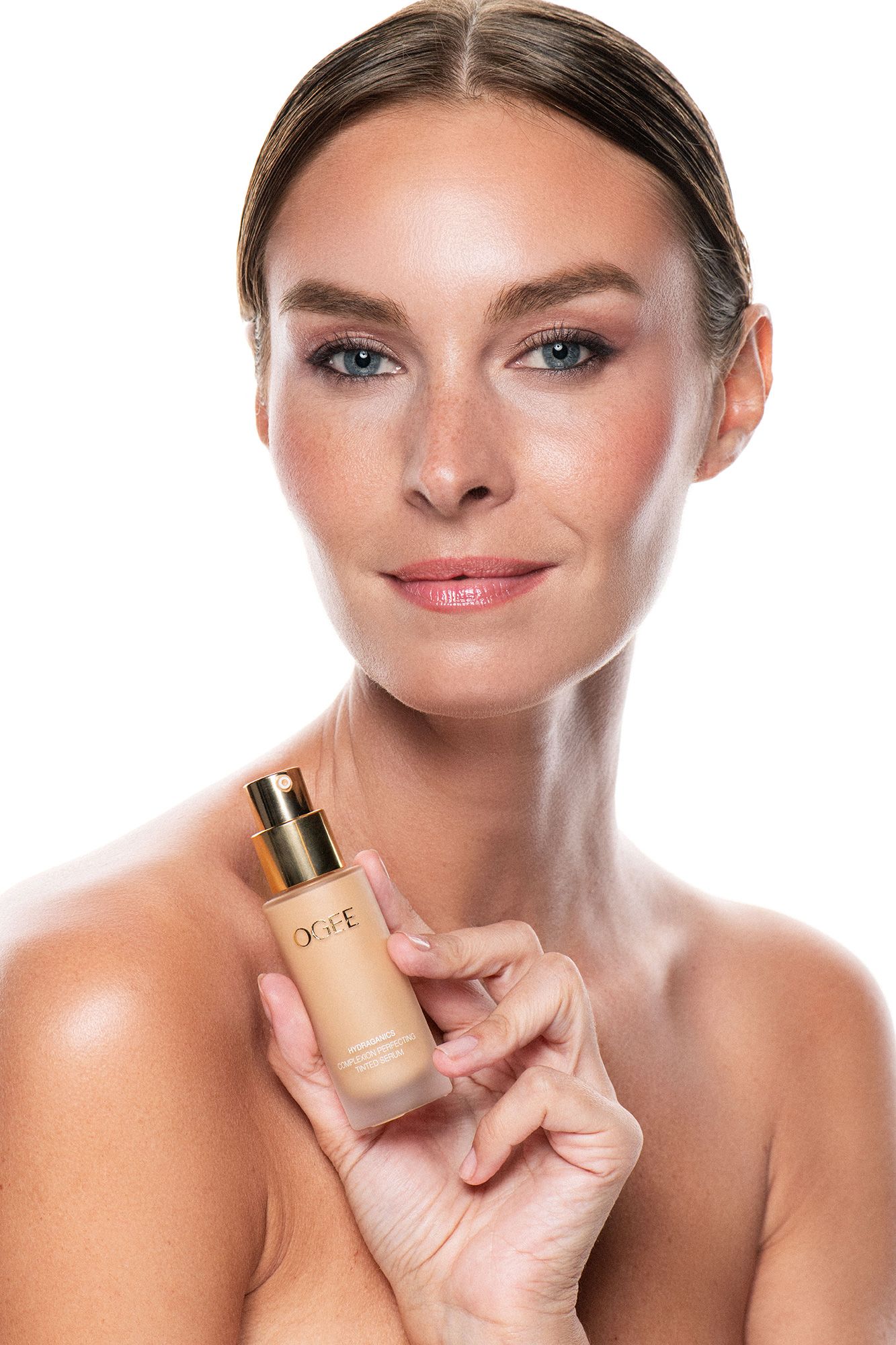 Woman holding a ORPE liquid foundation bottle, showcasing flawless skin and natural makeup on white background.