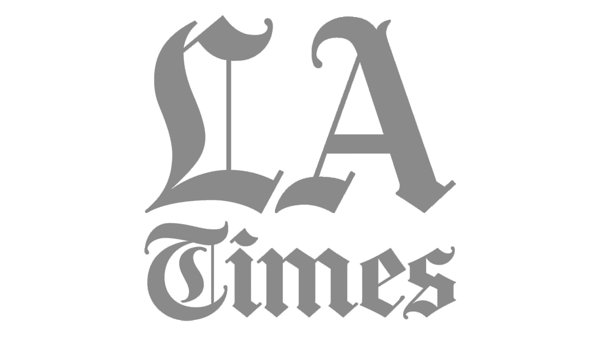Gray LA Times logo featuring large stylized letters L and A above the word Times in classic serif font.