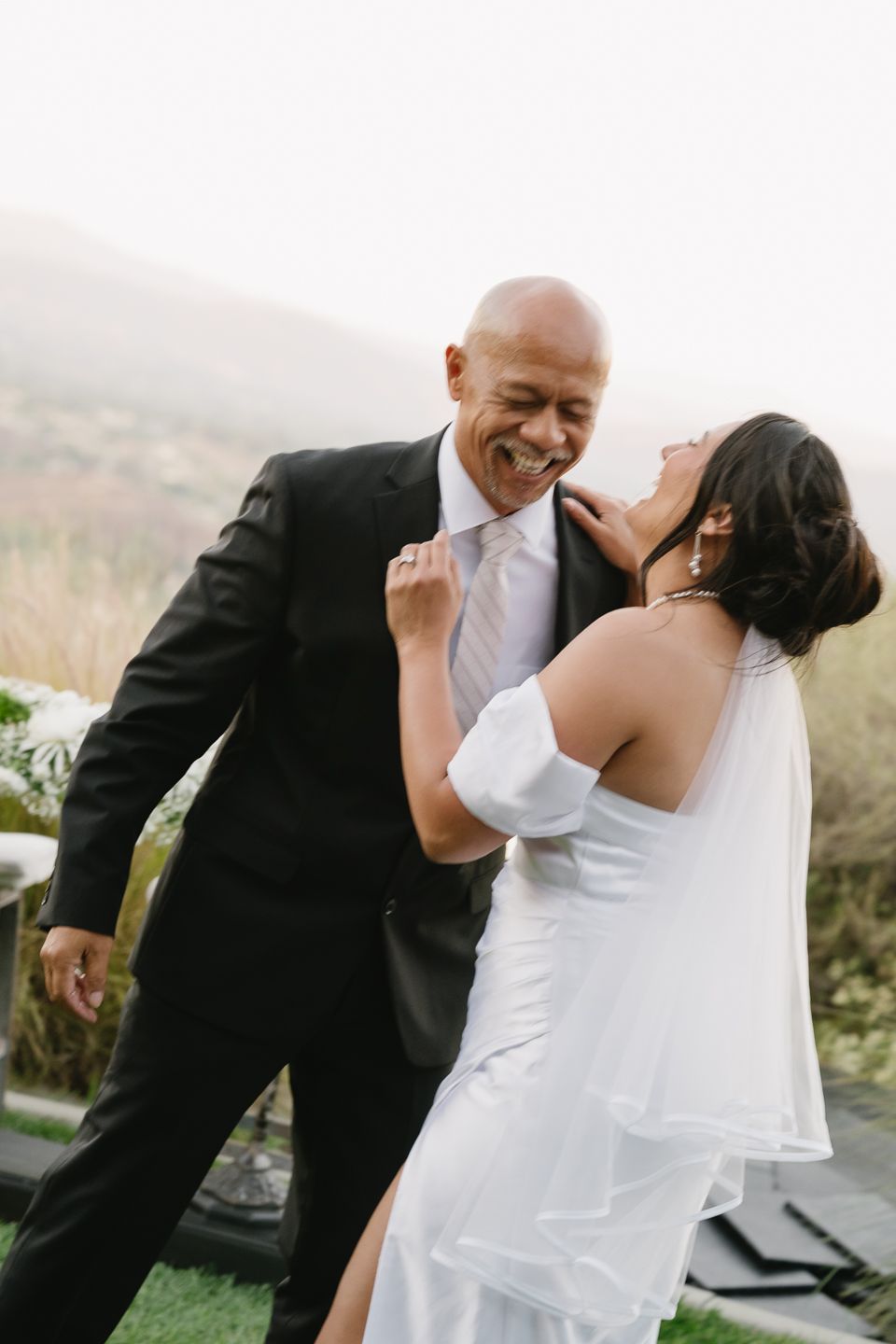 Joyful bride and groom laughing together with dad in Temecula, CA wedding