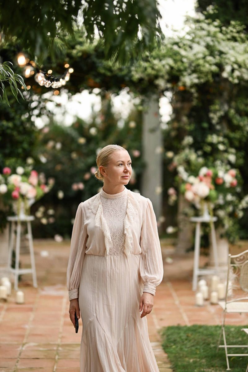 Olga Prudko, expert Costa Blanca wedding planner, walking through an outdoor garden venue decorated with string lights.