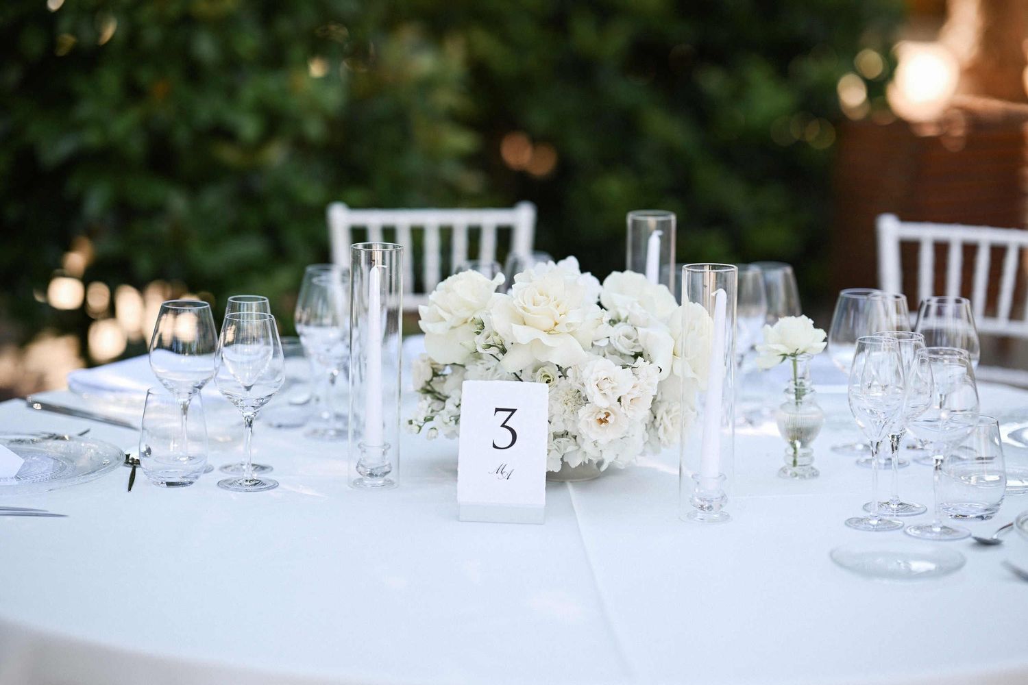 Elegant wedding reception table setting with white rose centerpieces and candles at Finca El Senyoret