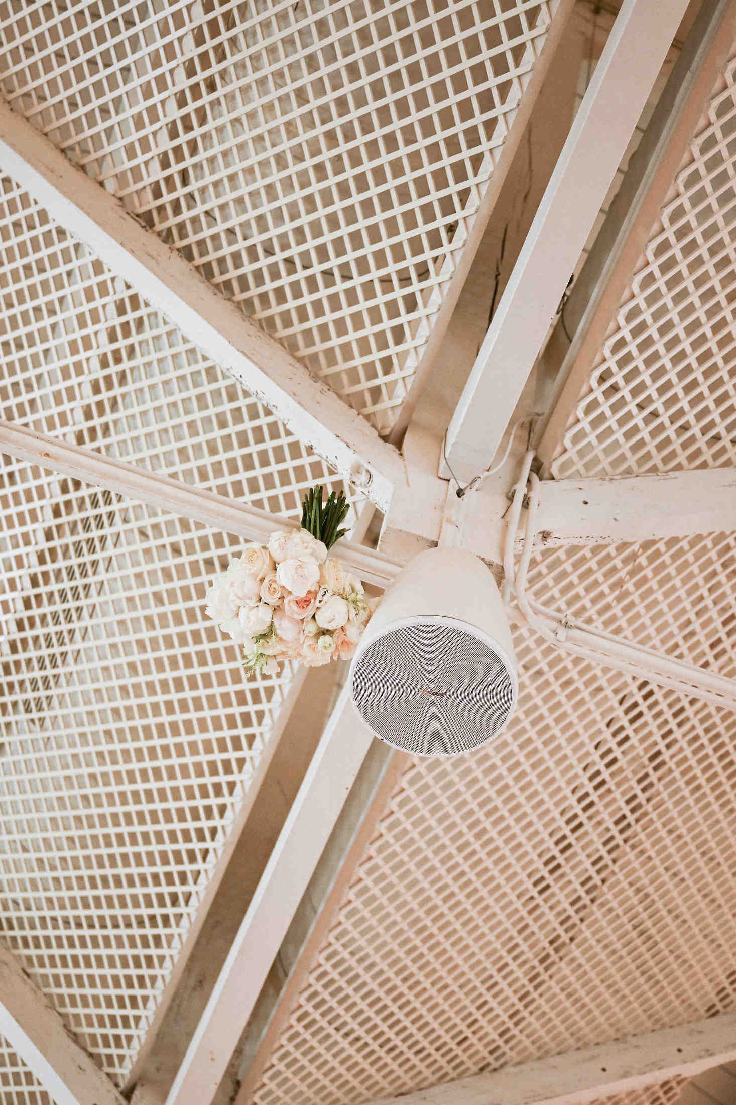 The bridal bouquet accidentally stuck on a ceiling beam during the toss, a memorable and funny moment at a Valencia wedding.