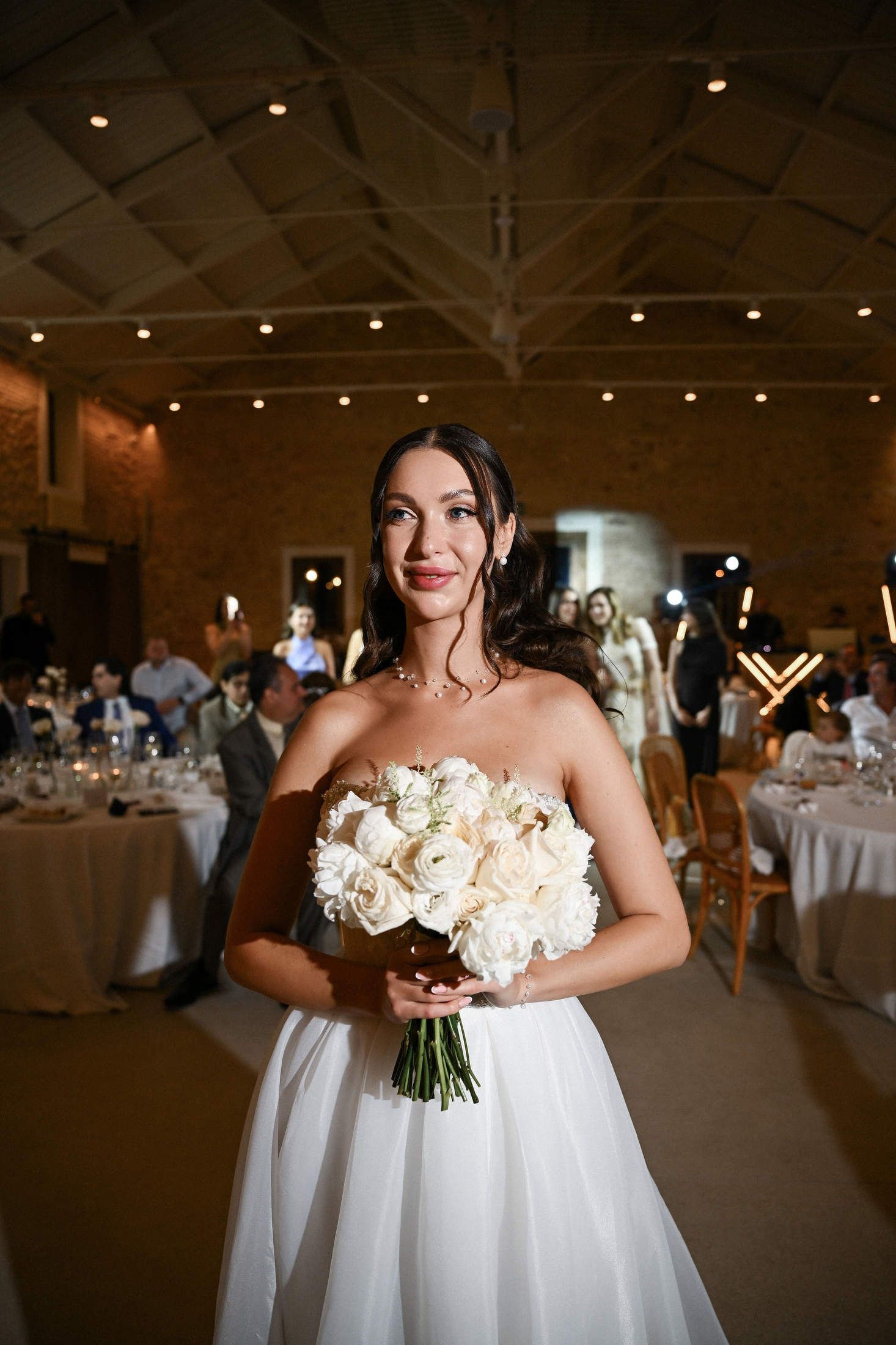 Beautiful bride holding a white bouquet during her elegant indoor wedding reception at a historic stone finca el canonigo