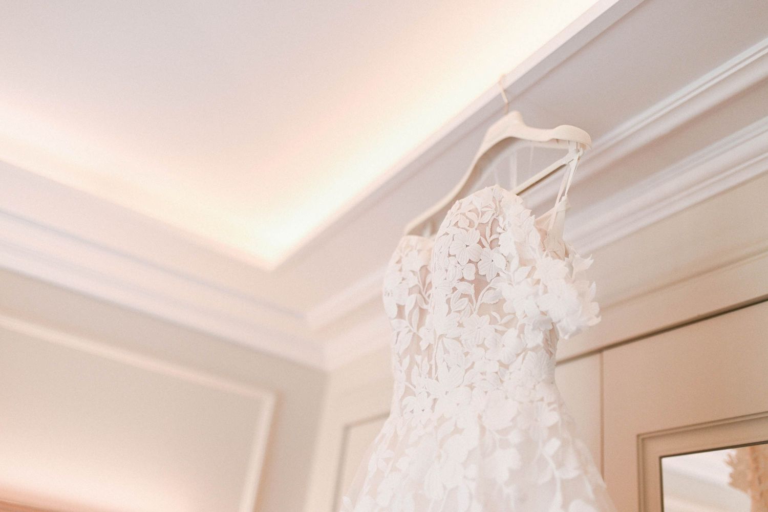 Elegant lace wedding dress hanging in a bridal suite before a destination wedding at Finca El Senyoret