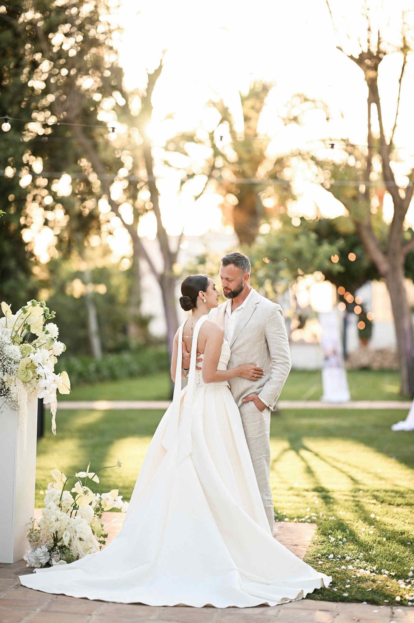 Happy bride and groom entering their outdoor wedding reception while guests cheer at Villa Paula in Valencia.