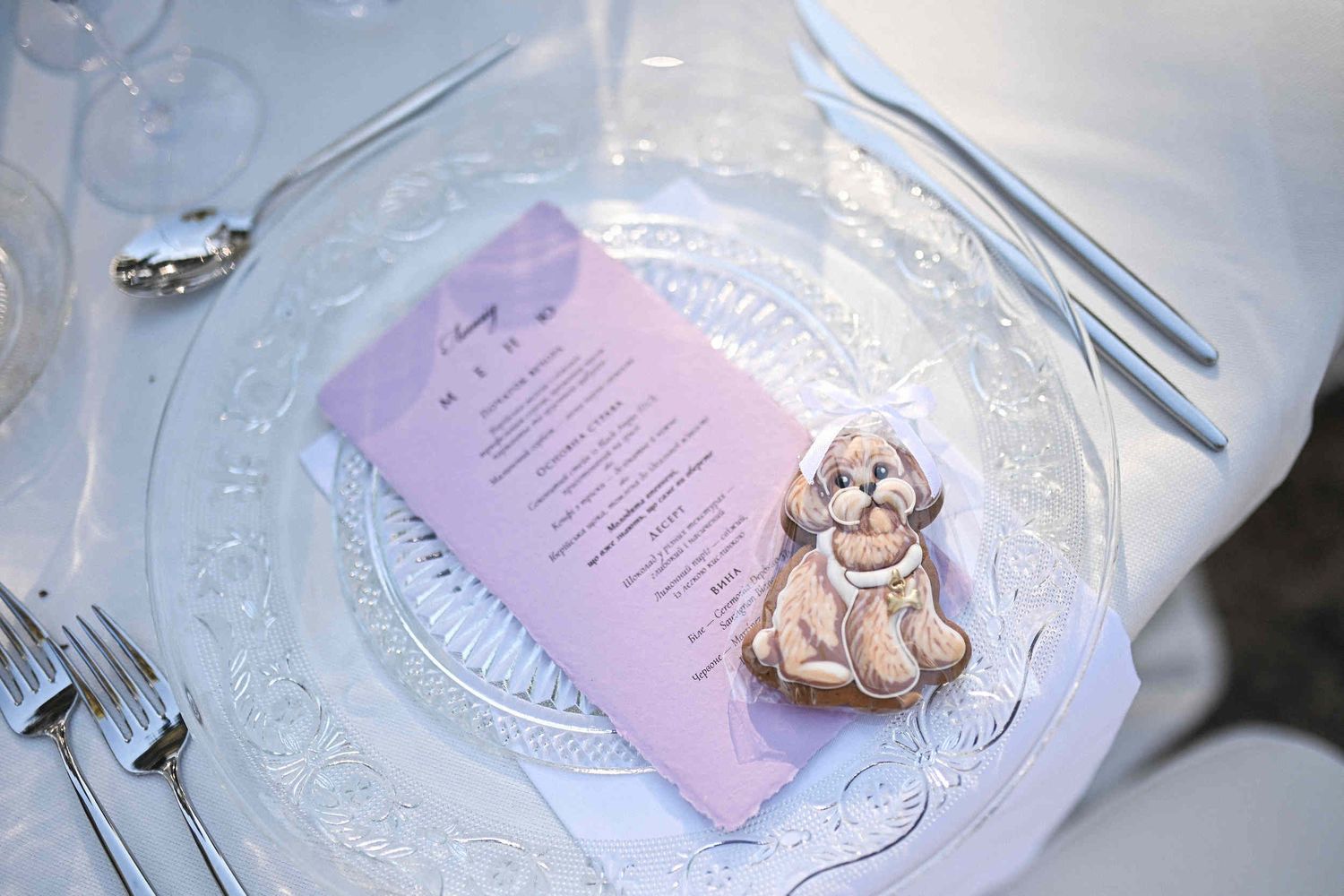 Close-up of a custom dog-shaped gingerbread cookie wedding favor placed on a glass plate at Finca El Senyoret.