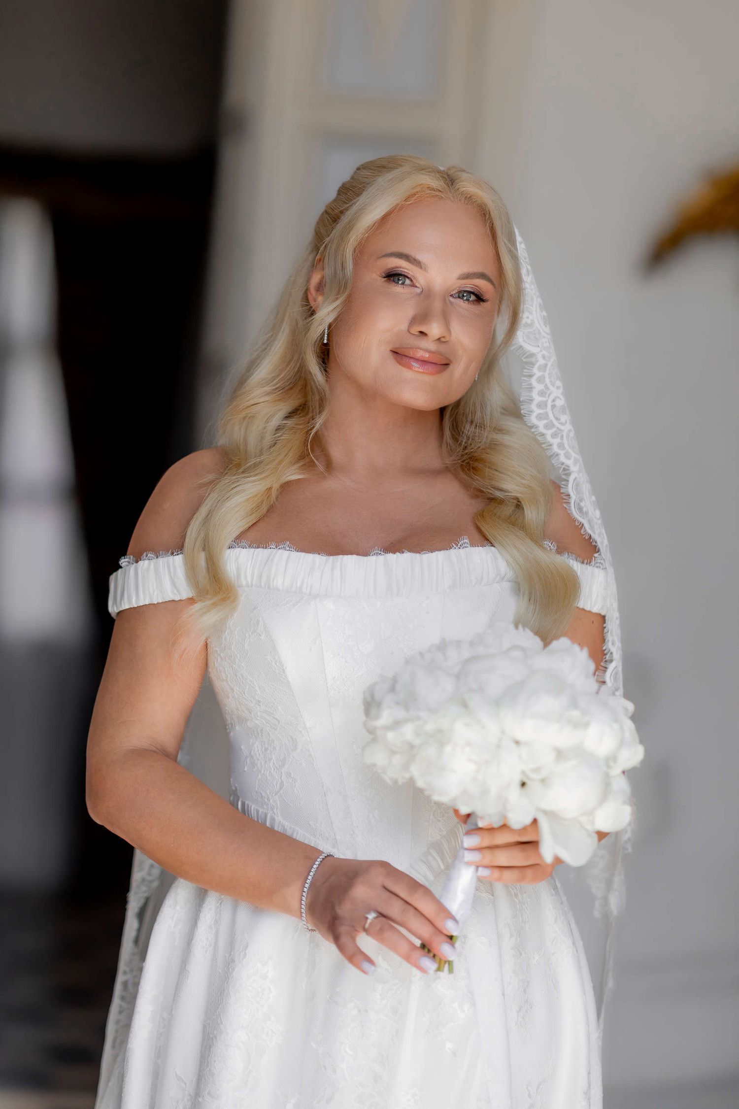 Close-up of a happy bride holding a white bouquet, ready for her destination wedding planned in Altea.