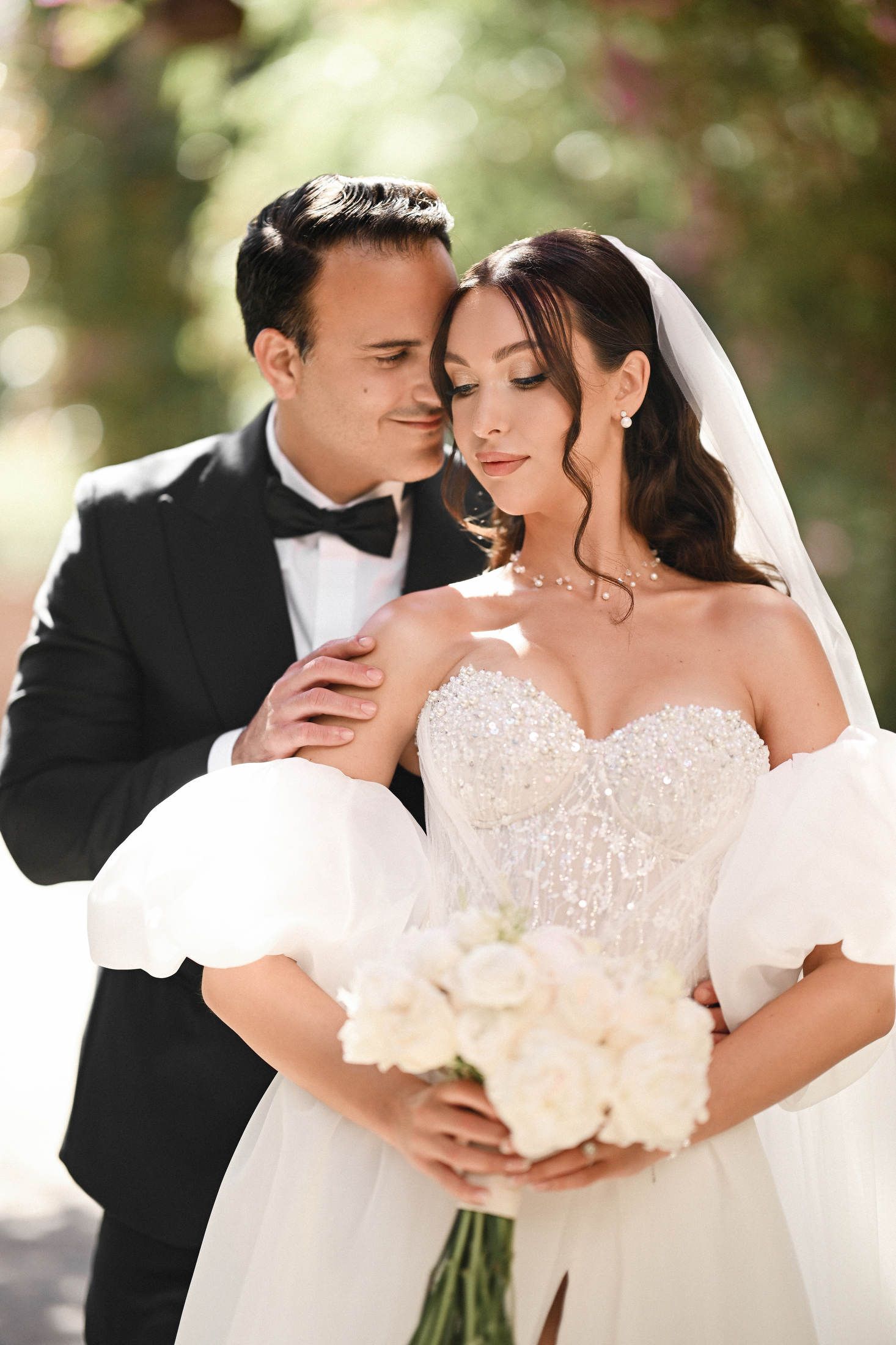 Romantic outdoor portrait of a bride and groom in a tuxedo and puff-sleeve dress at a beautiful Valencia wedding.